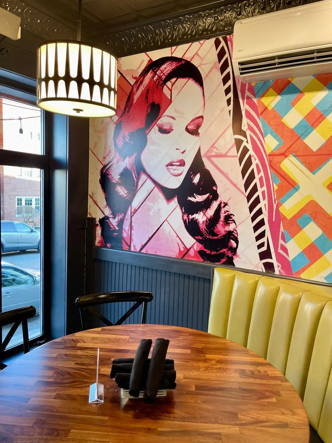 The dining room at Local 149 in Boston is an OpenTable restaurant. It features a mural of a woman’s face and colorful accents on the wall and booth.