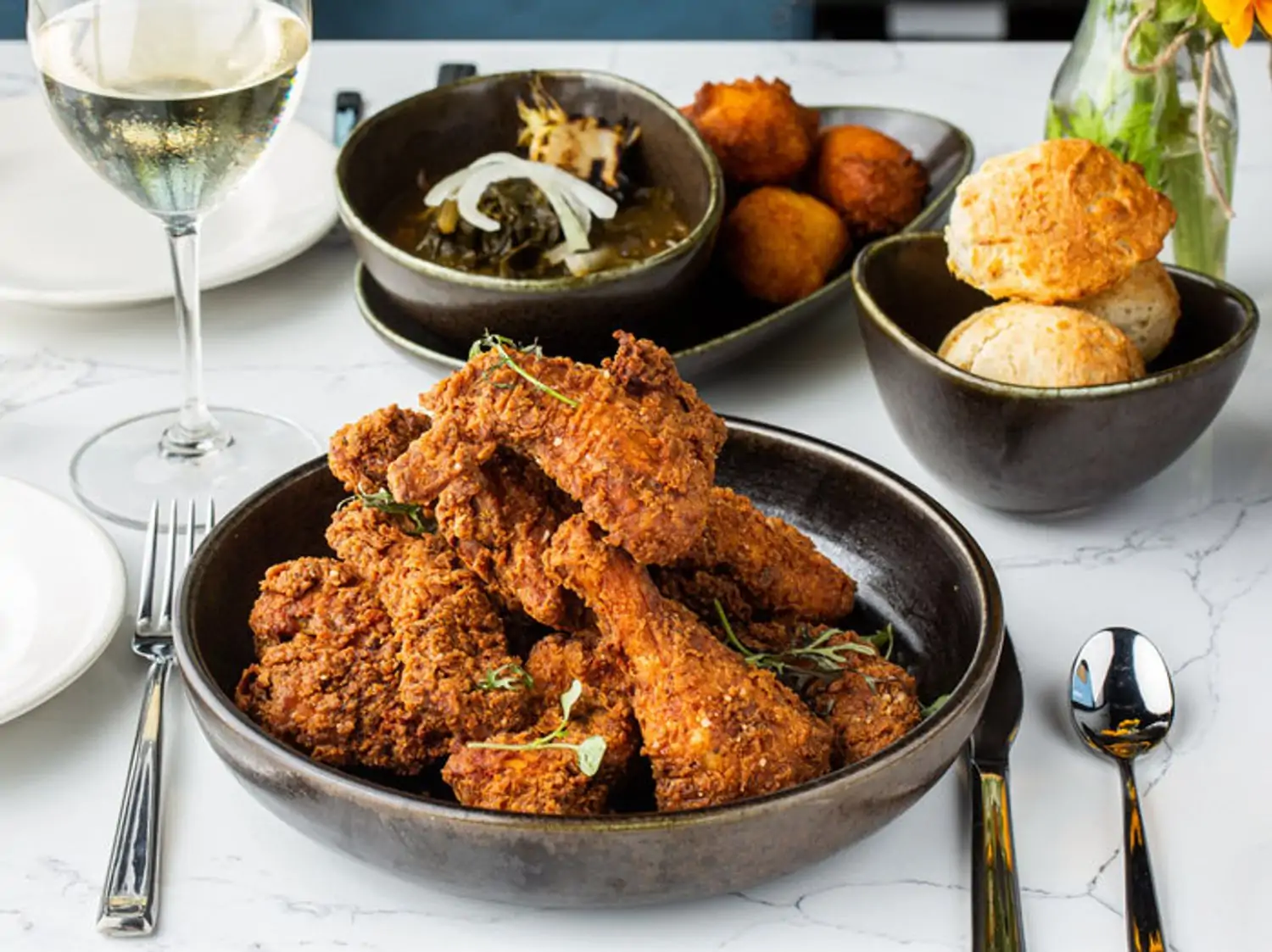 A family-style platter of duck-fat fried chicken with drop biscuits is served at Roots Southern Table, one of the top Black-owned restaurants in Dallas on OpenTable