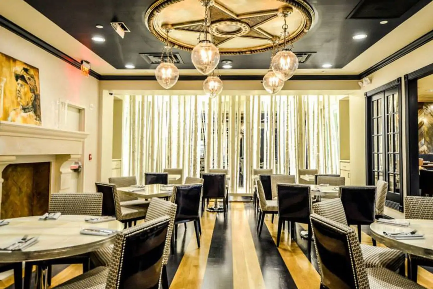 A five-star emblem on the ceiling, alternating black and hardwood floor panels, and a fireplace with a painting of President Roosevelt over it, this is how the dining room looks like at Teddy & The Bully Bar, one of the best restaurants Dupont Circle, DC—bookable on OpenTable.