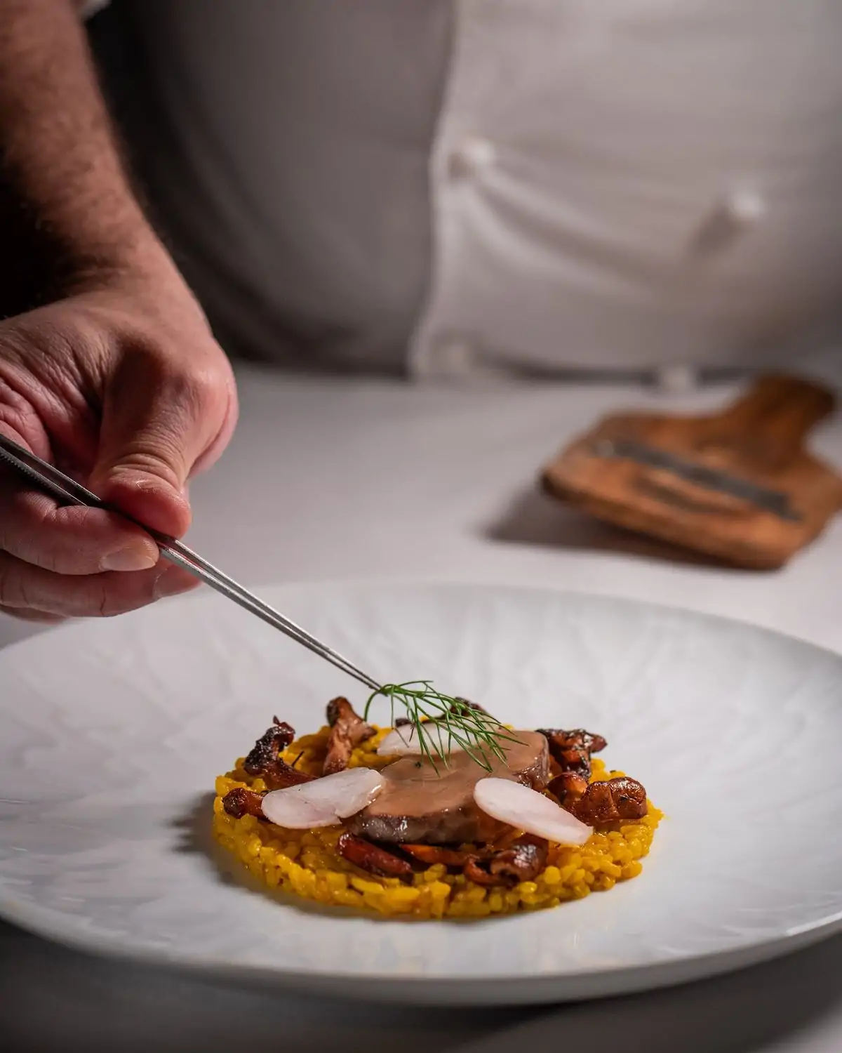 A chef places dill on a rice dish at Xiquet by Danny Lledó, a best MICHELIN Star restaurant in Washington DC, on OpenTable.