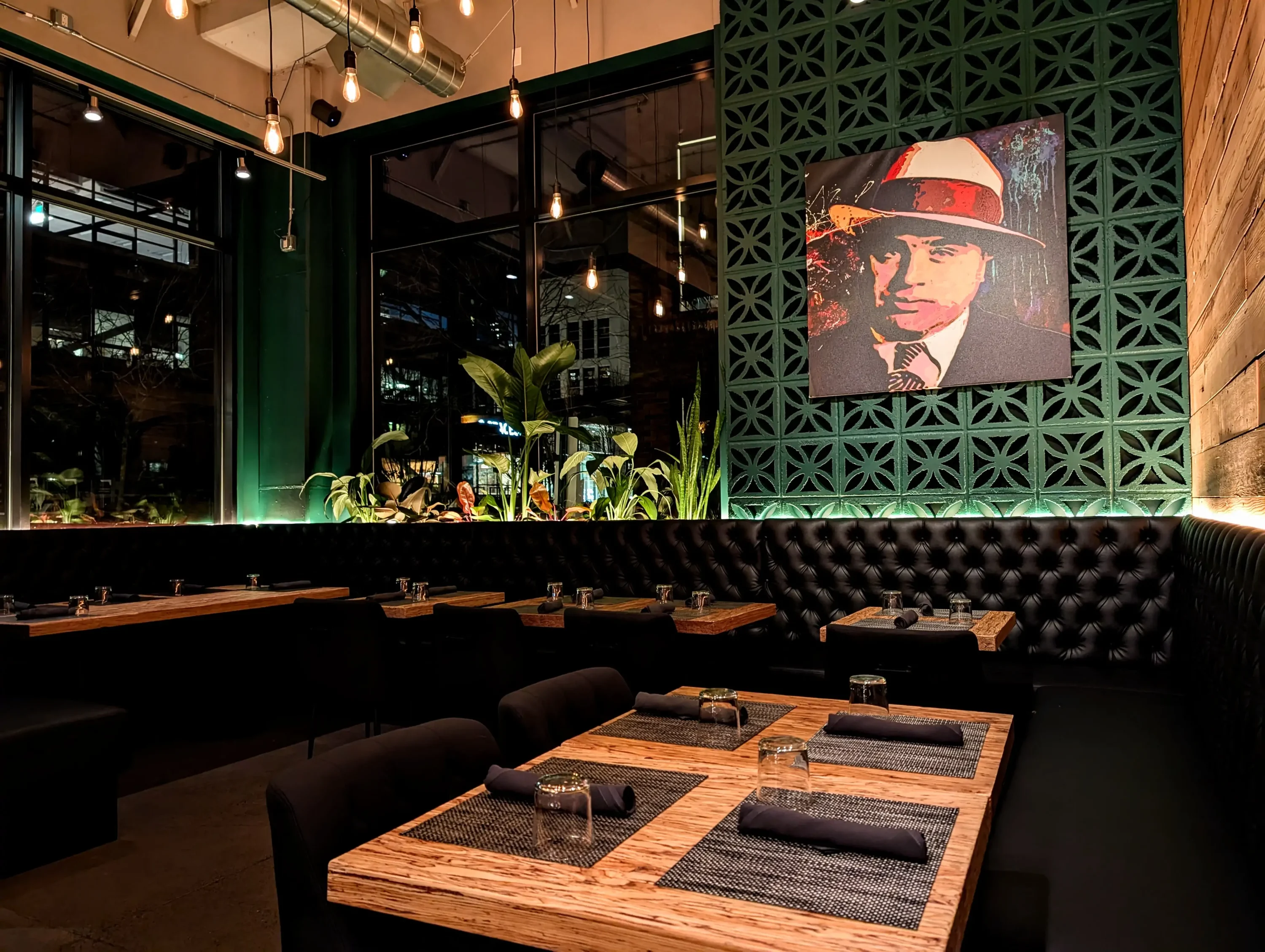 The interior of the Portland restaurant Bistecca with wooden tables and exposed lightbulbs hanging from the ceiling