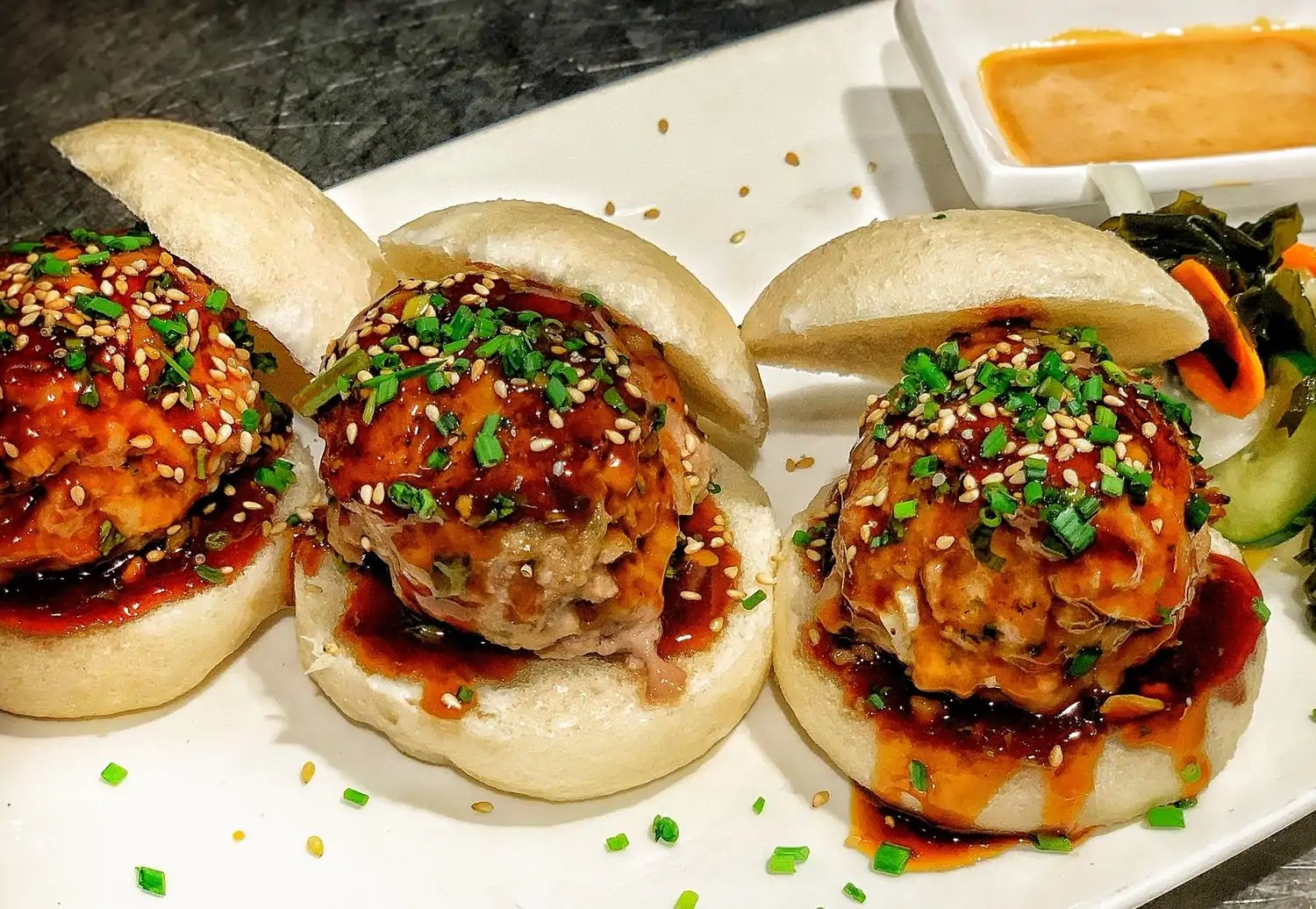 A close-up of three bao burgers at Moani Waikiki Island Bistro & Bar, one of the best family restaurants in Honolulu. Book on OpenTable.
