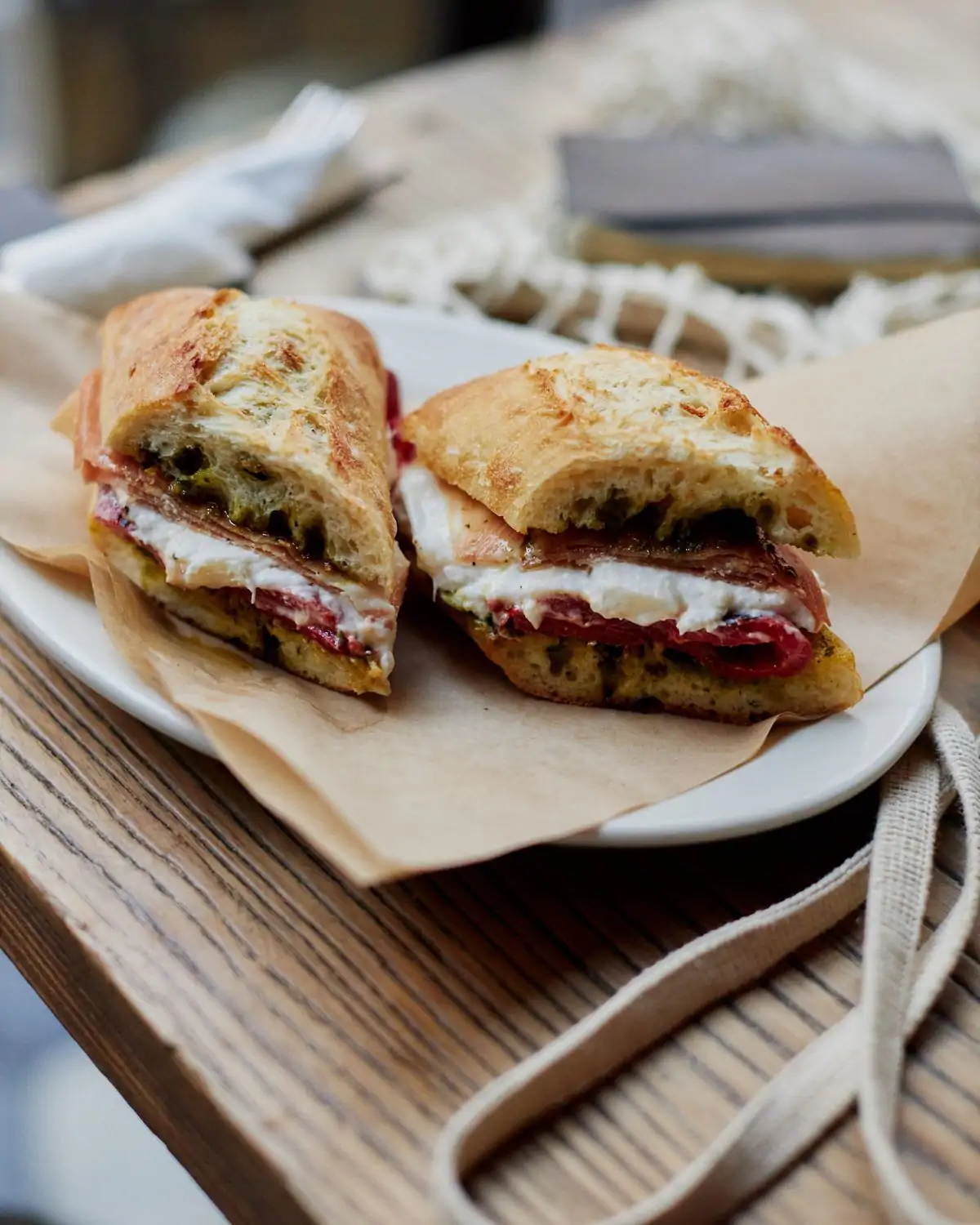 A plate containing a sandwich on a toasted baguette with cheese and meat at Zinqué in Century City, Los Angeles, bookable on OpenTable.