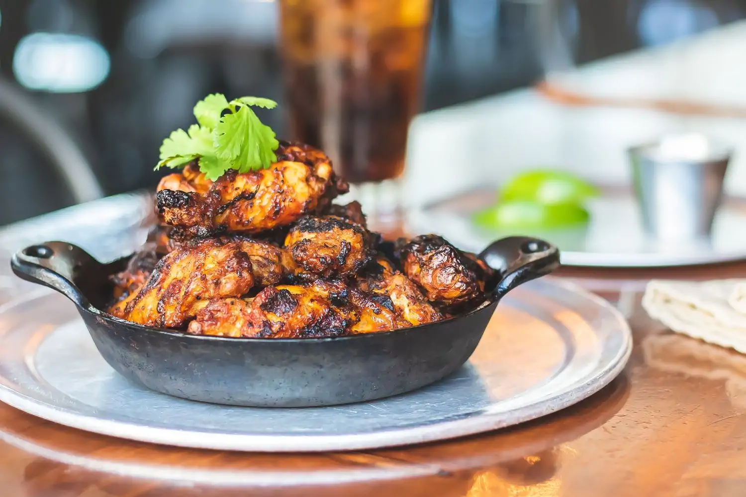 A skillet full of chicken wings with garnish at Beardslee Public House, one of the best family restaurants in Seattle, bookable on OpenTable.