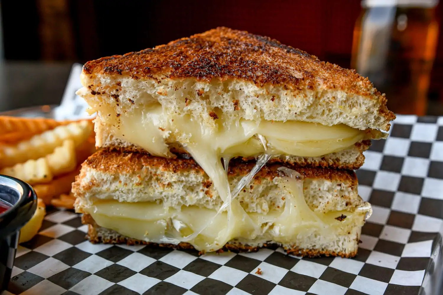 A perfectly toasted grilled cheese sandwich served with golden fries at Blu Ox at Bad Axe Throwing, Nashville. Book on OpenTable.