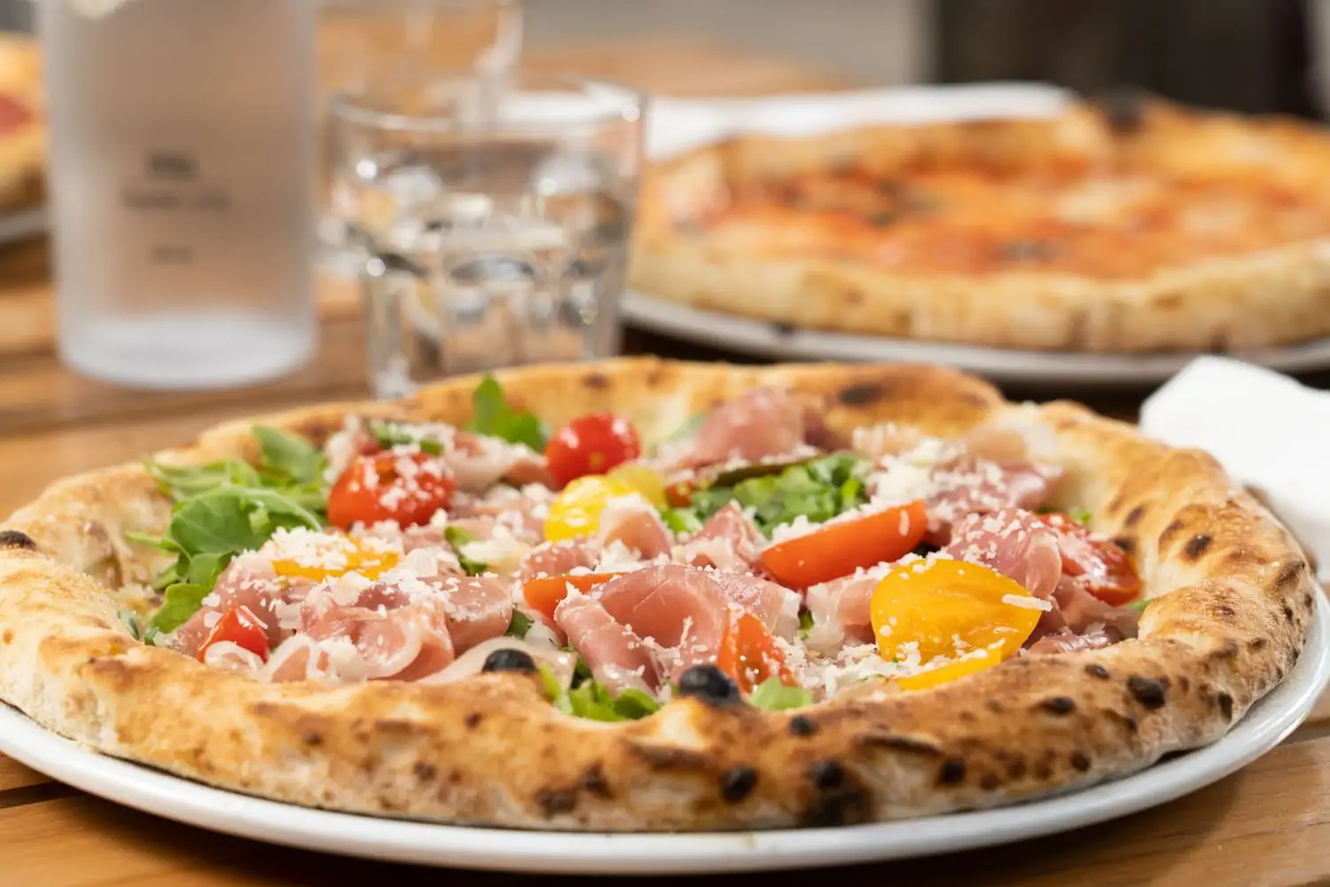 A close-up of a Neapolitan pizza topped with prosciutto and vegetables at Ironside Pizza, one of the family friendly restaurants in Miami for pizza fans. Book on OpenTable.