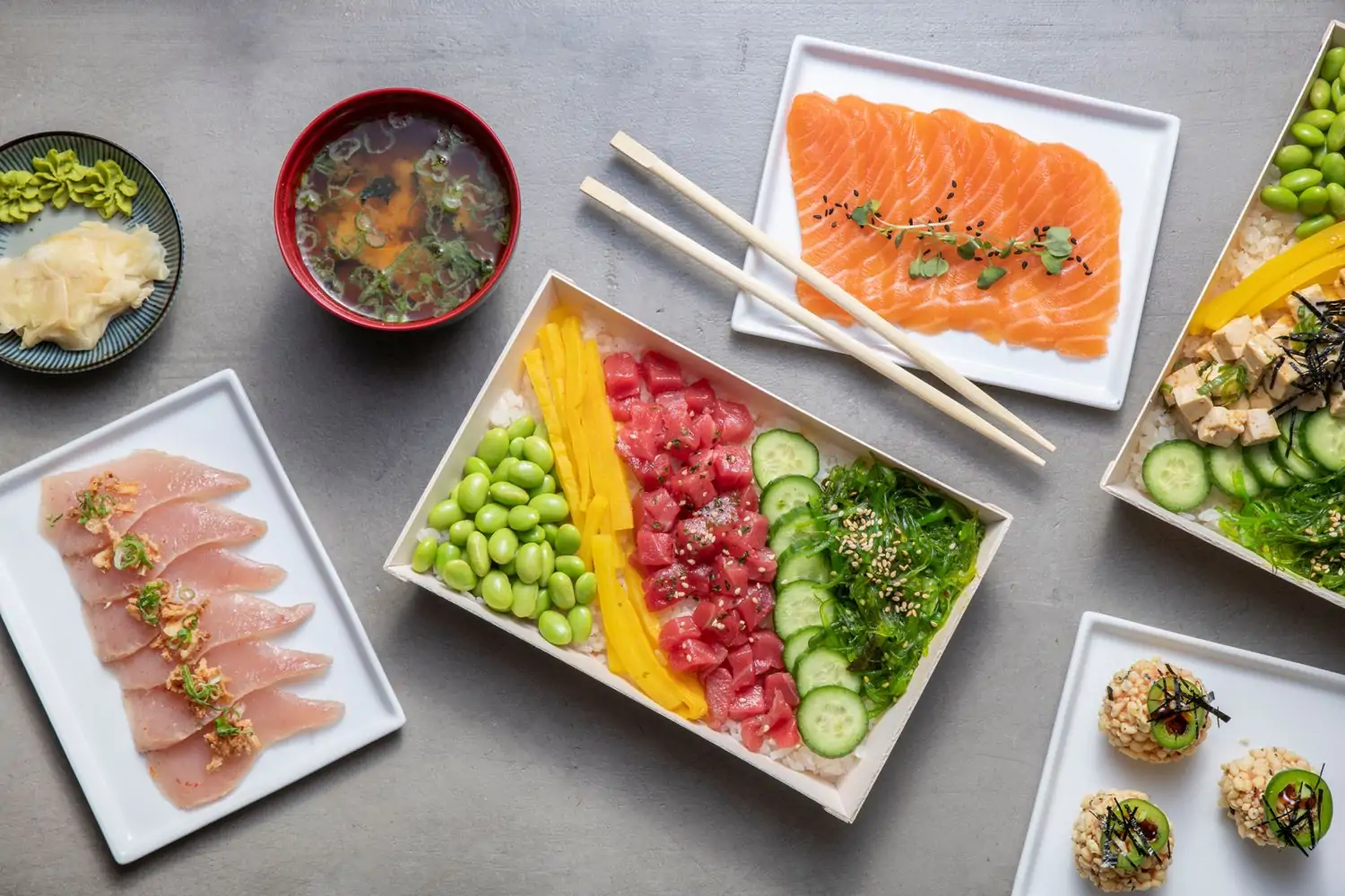 A table setting with plates of raw fish, fresh chilled veggies, soups, and tofu at The HRB Experience, in Los Angeles, on OpenTable.
