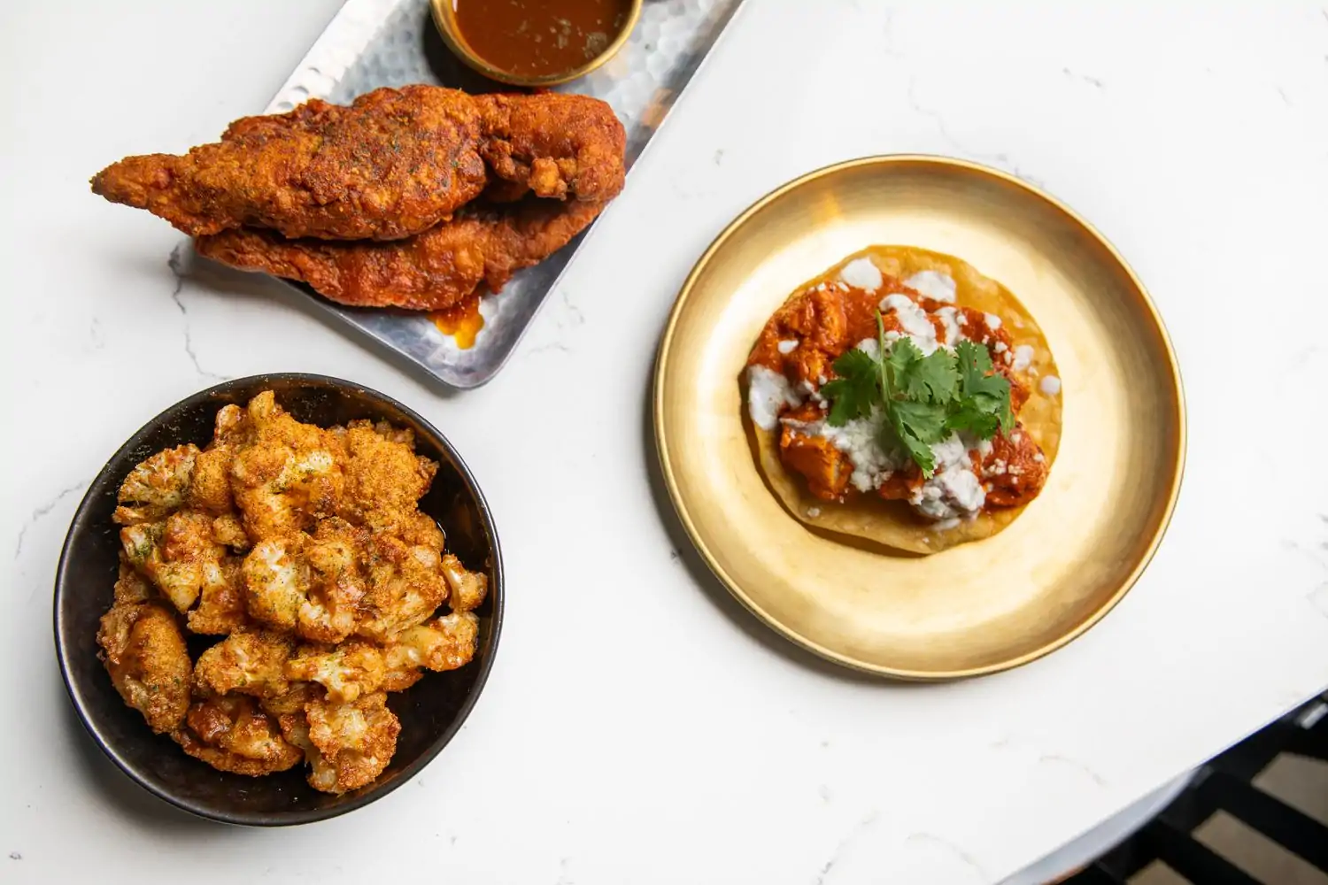 A table with three Indian plates at Turmeric & Co., one of the best family friendly restaurants in Nashville, on OpenTable.