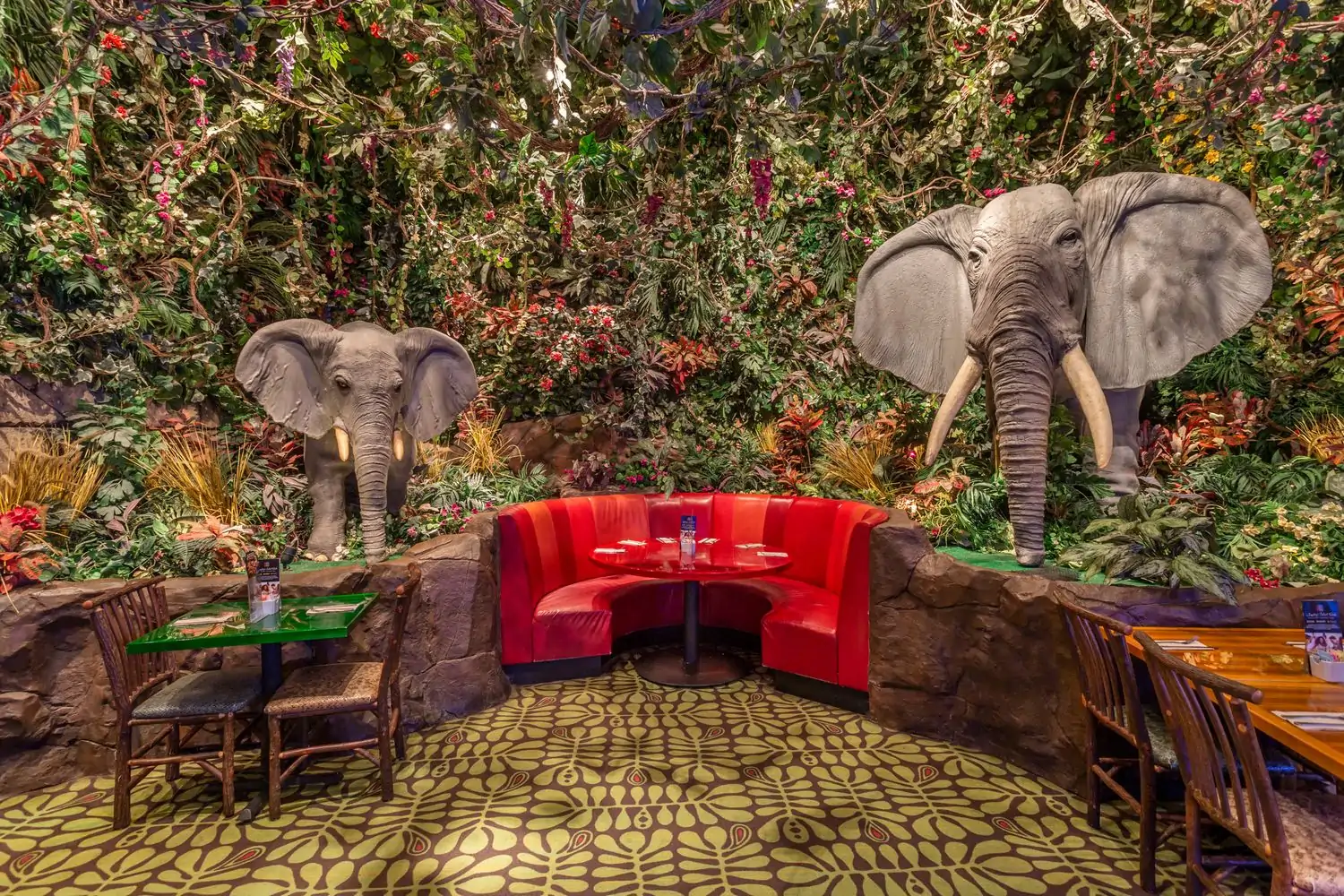The dining room with jungle-themed decor and two large elephant statues of the Rainforest Cafe, in Nashville. Available on OpenTable.