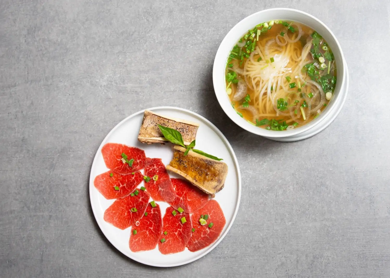 Plates of carpaccio, bone marrow, and pho at An Di Dzo, one of the best family restaurants in Honolulu for Vietnamese cuisine. Book on OpenTable.