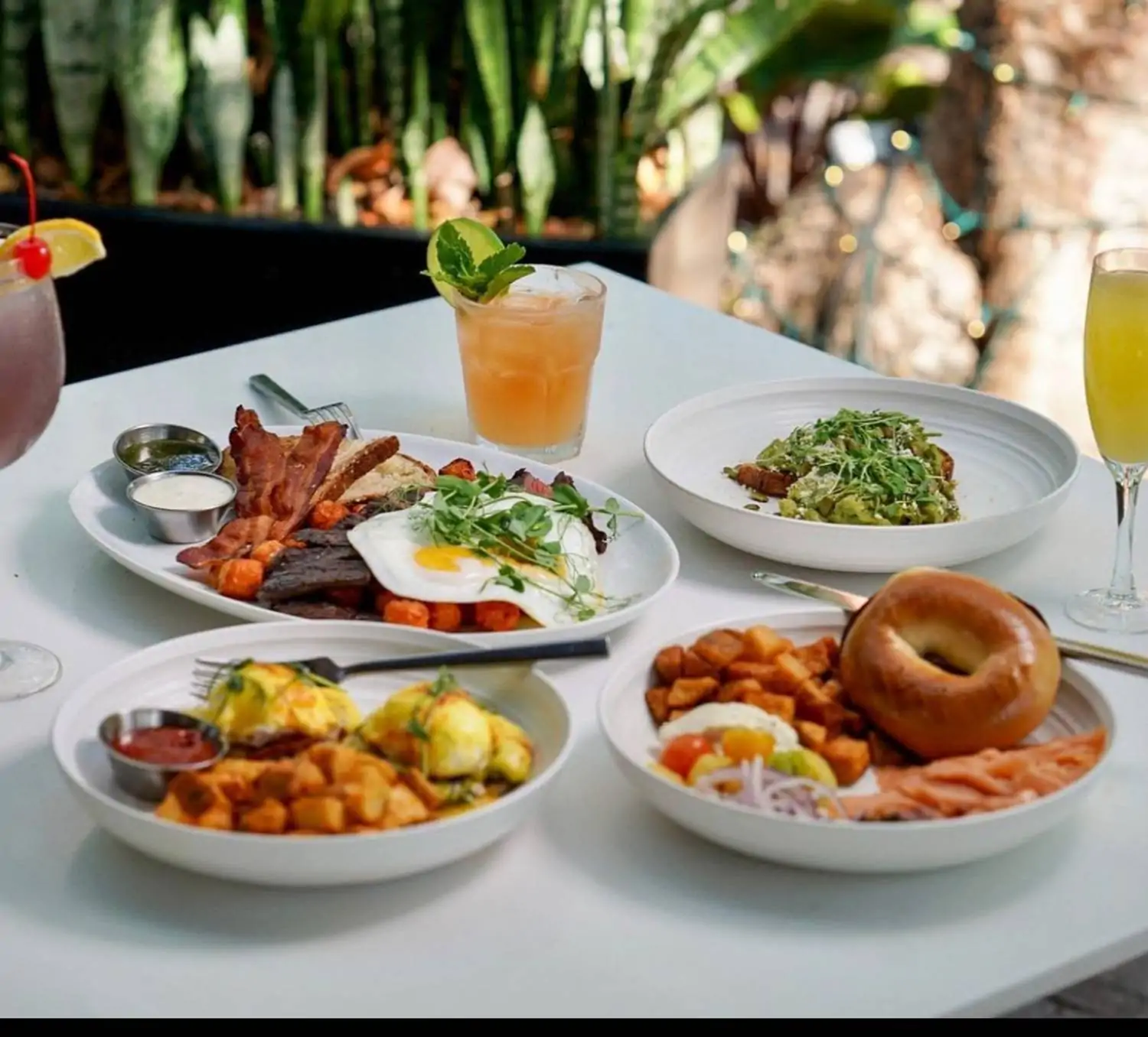 A white table set with four contemporary American breakfast plates at Glass & Vine, one of the fun family restaurants in Miami. Book on OpenTable.