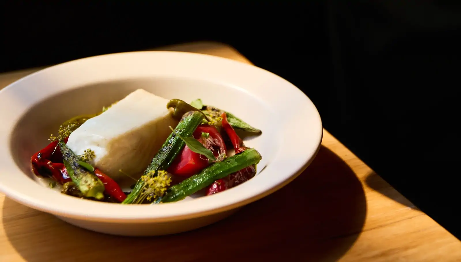 A white bowl with tofu and okra at Nashville restaurant Rolf and Daughters