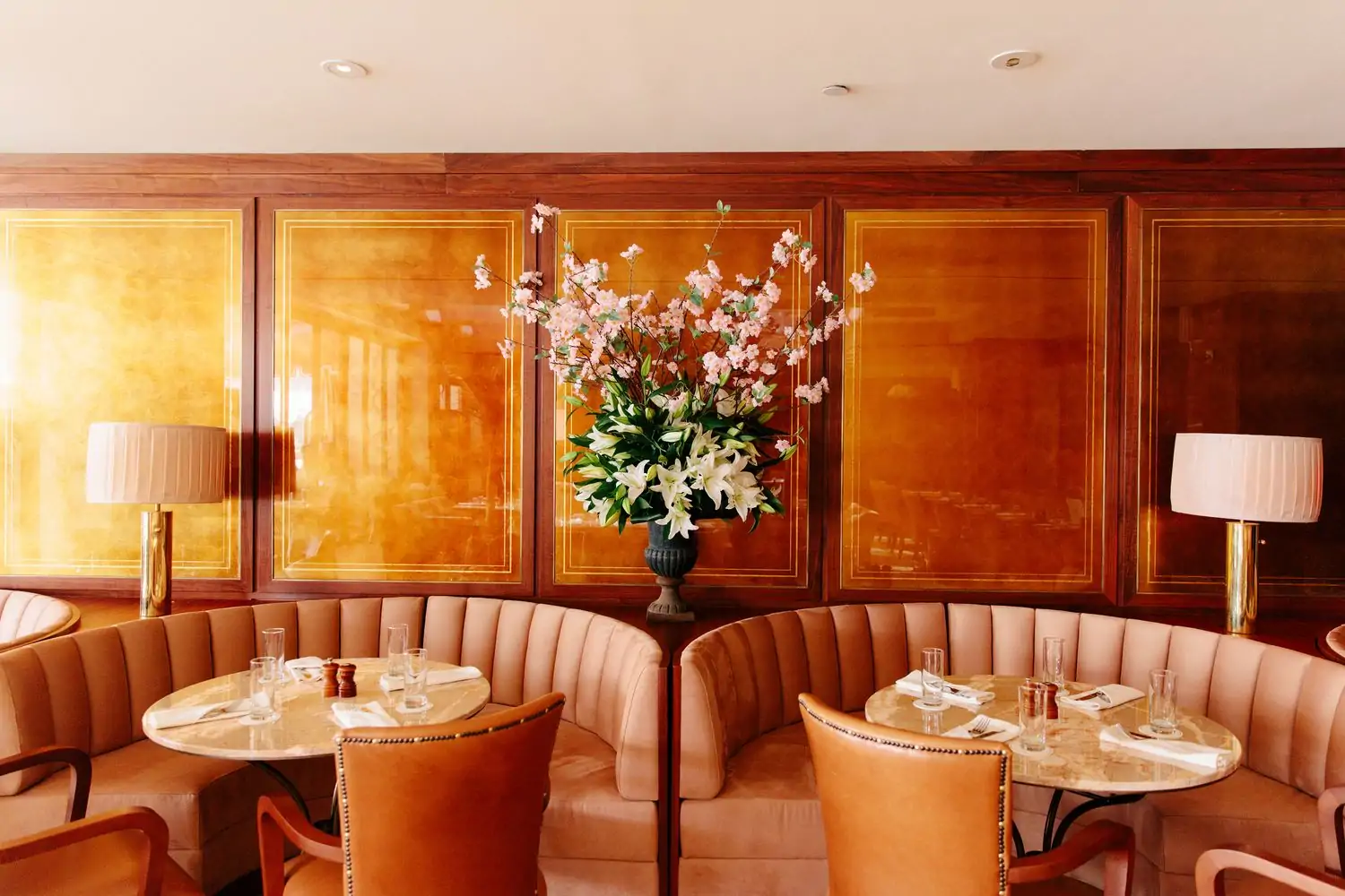 Soft pink suede seating and polished marble tables at The Tower Bar in Los Angeles. Book on OpenTable.