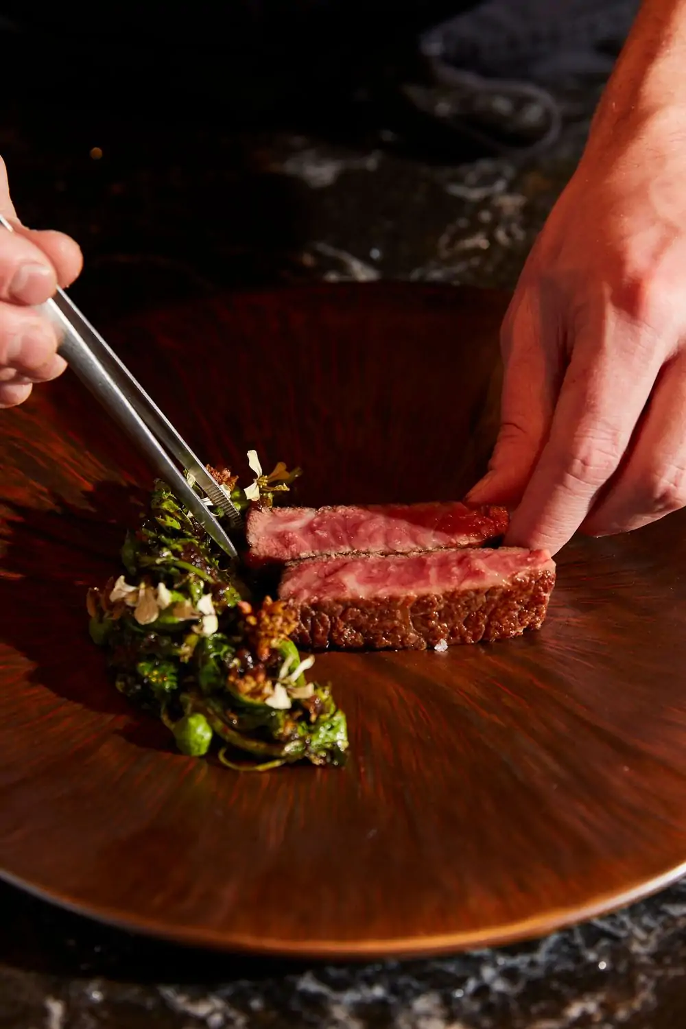 Two pieces of marbled wagyu beef on a black plate at Yingtao, one of the best Hell's Kitchen restaurants in NYC on OpenTable.
