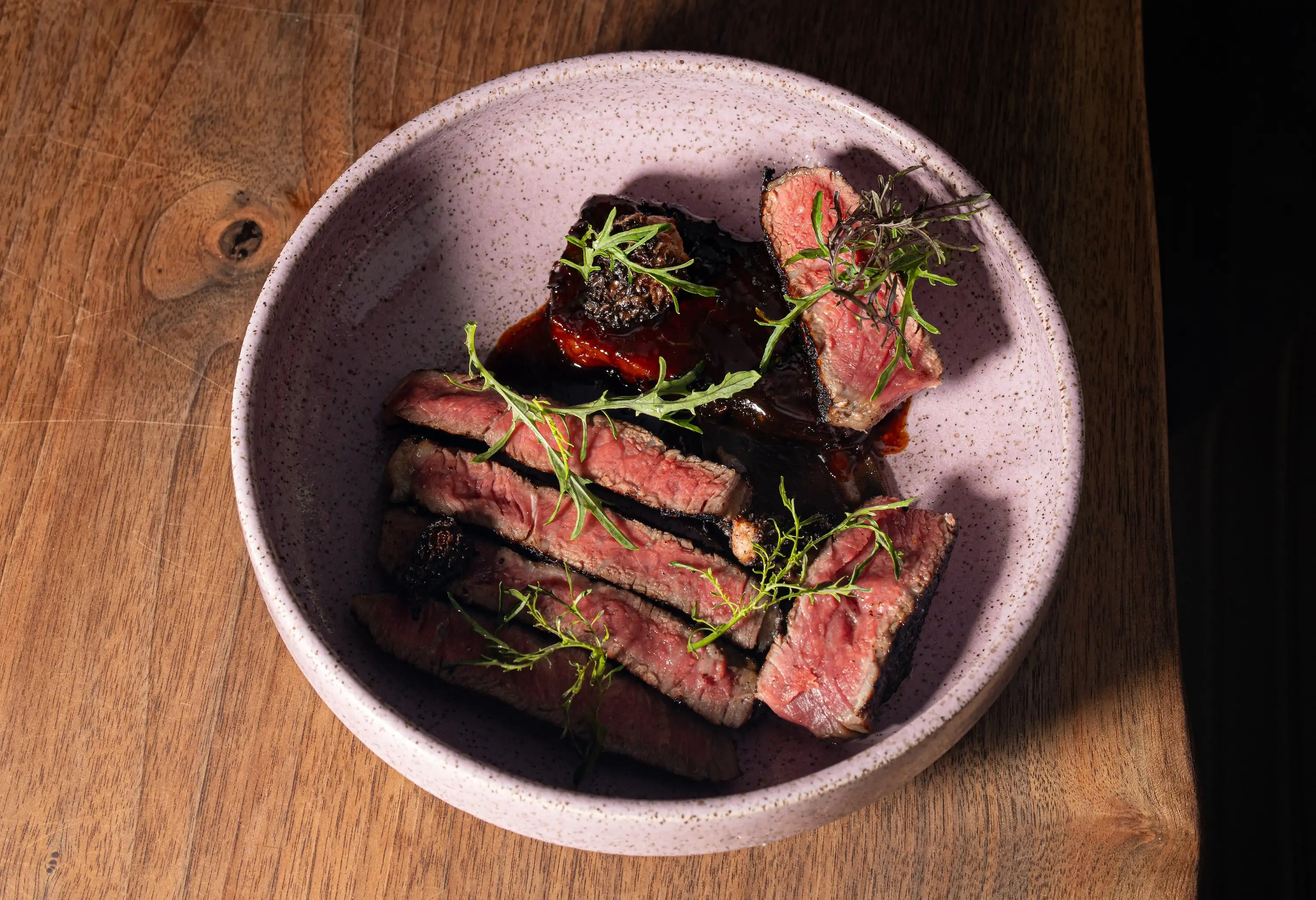 A steak dish in a pink plate at Philadelphia restaurant Emmett