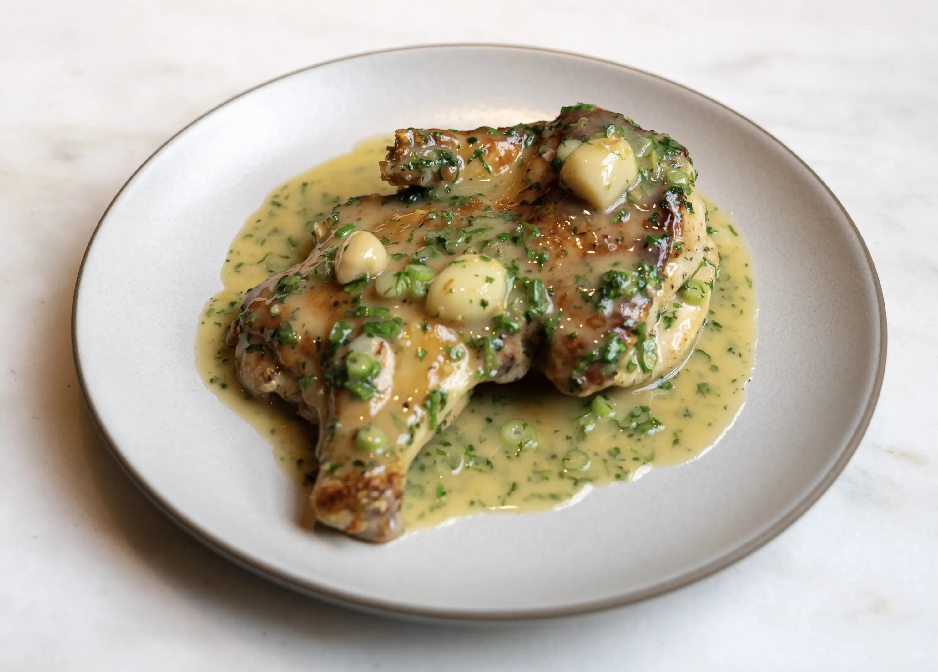 A roast chicken dish with a buttery sauce on top at Nashville restaurant Rolf and Daughters