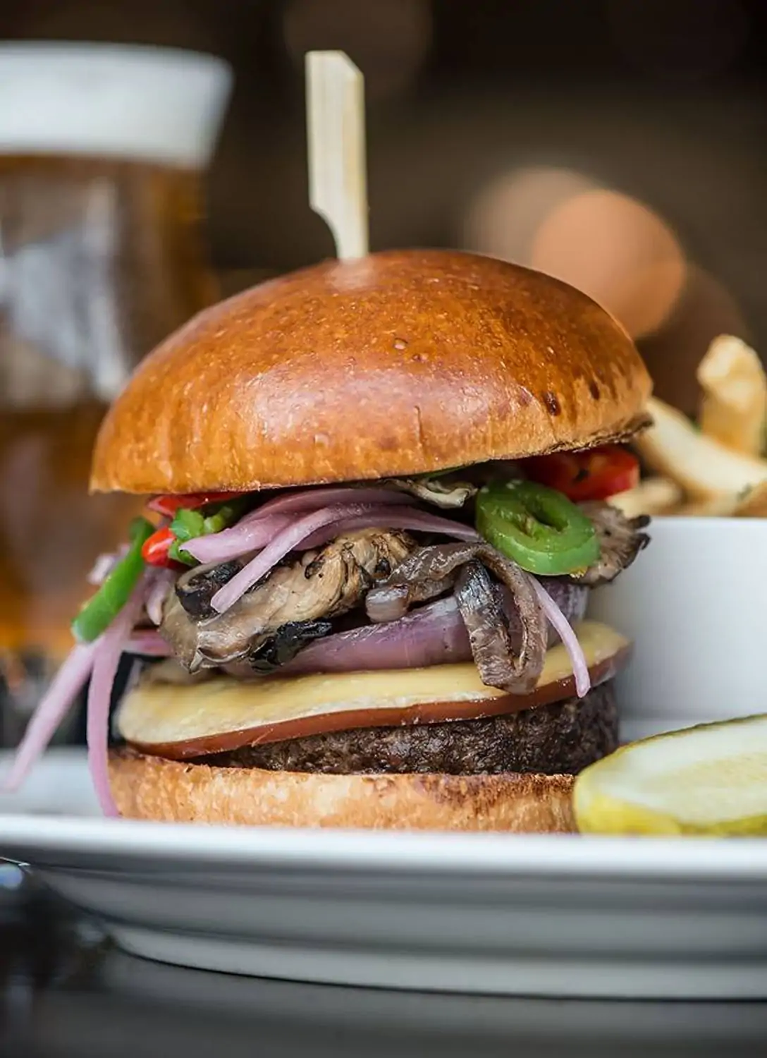 A burger with vegetables, fries, and pickles at The Gage, one of the best lunch restaurants in Downtown Chicago. Book on OpenTable.