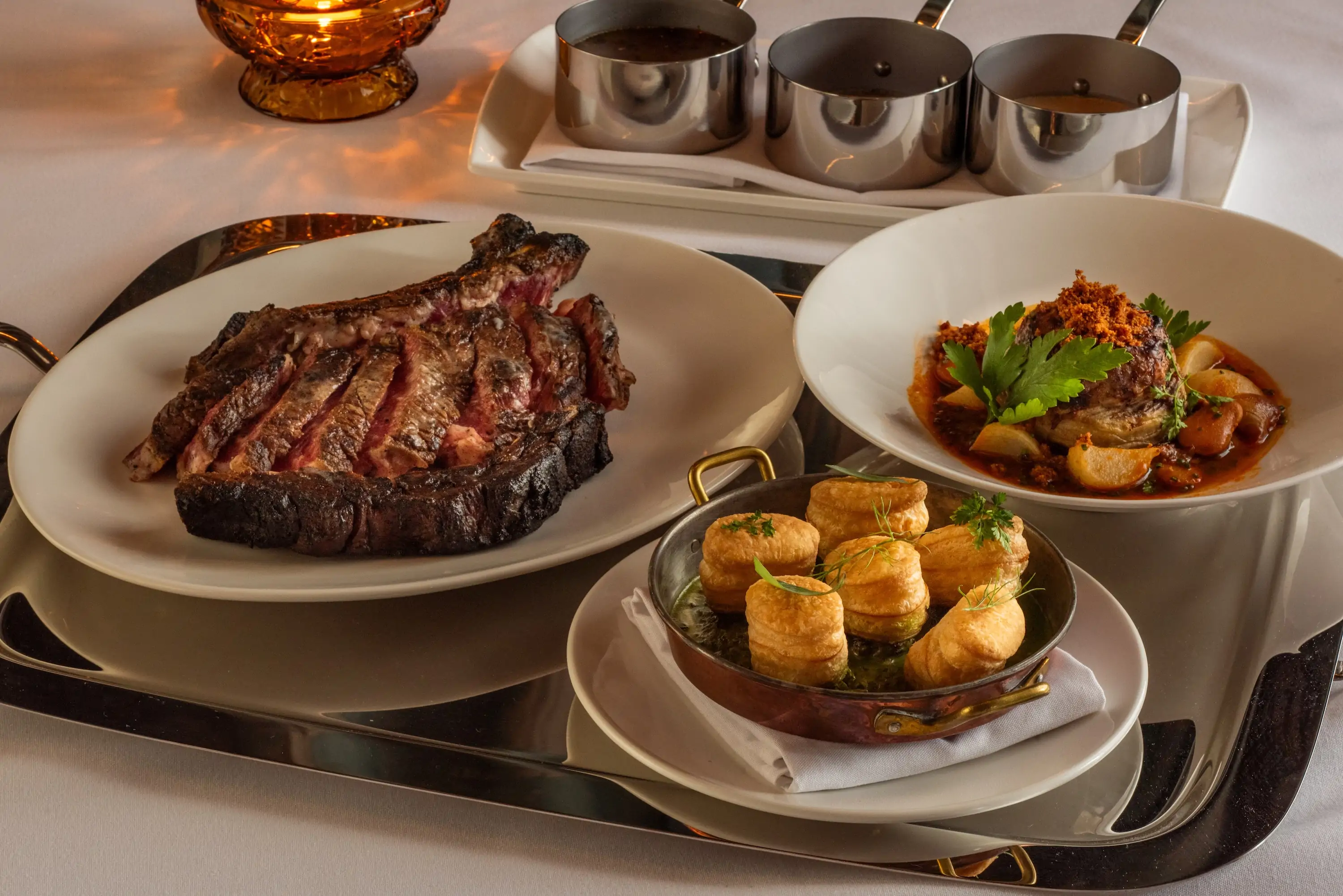 Three dishes on a table at Chicago steakhouse The Alston