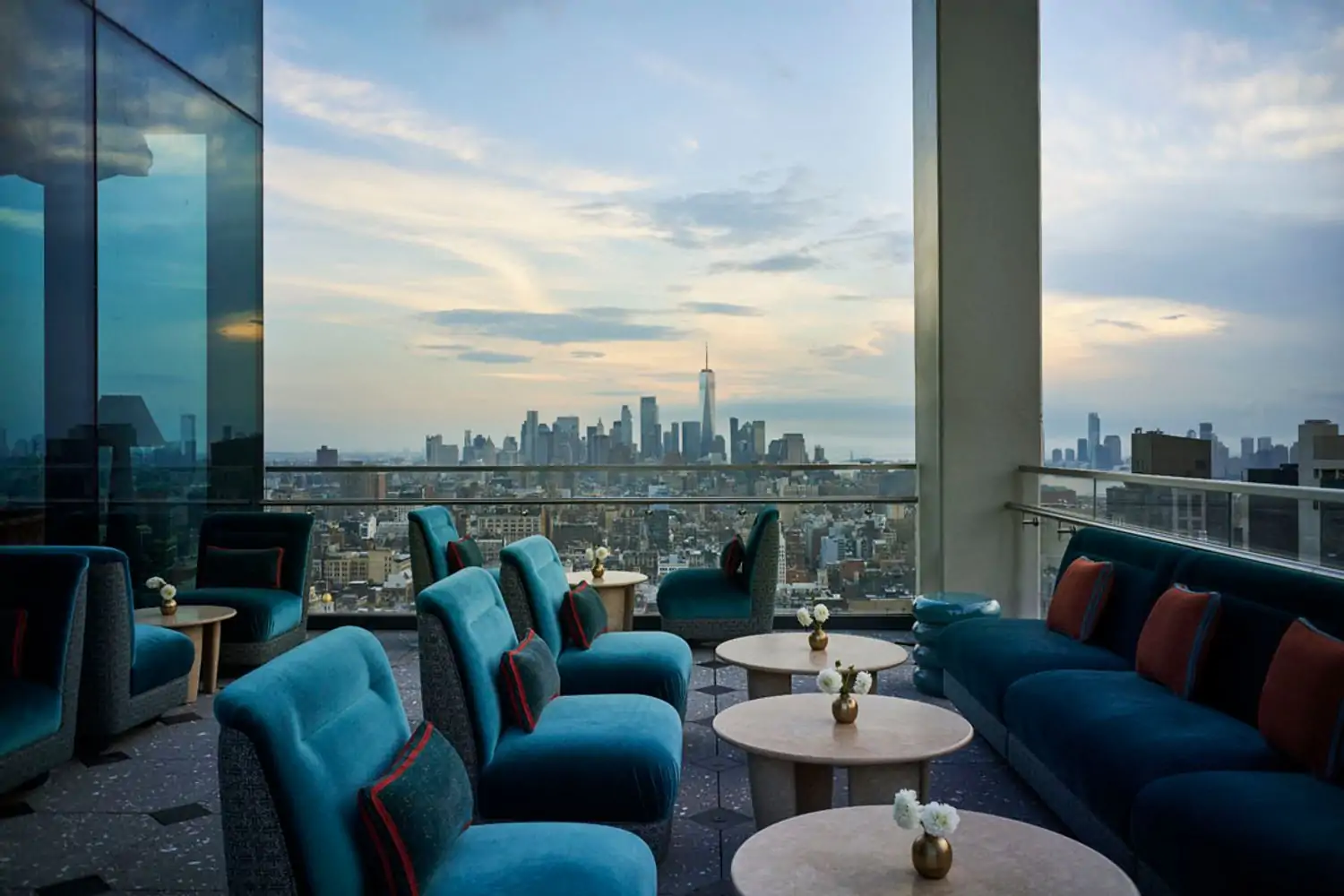 Plush blue seating on a rooftop with views of the NYC skyline at Nubeluz, an OpenTable restaurant in NYC.
