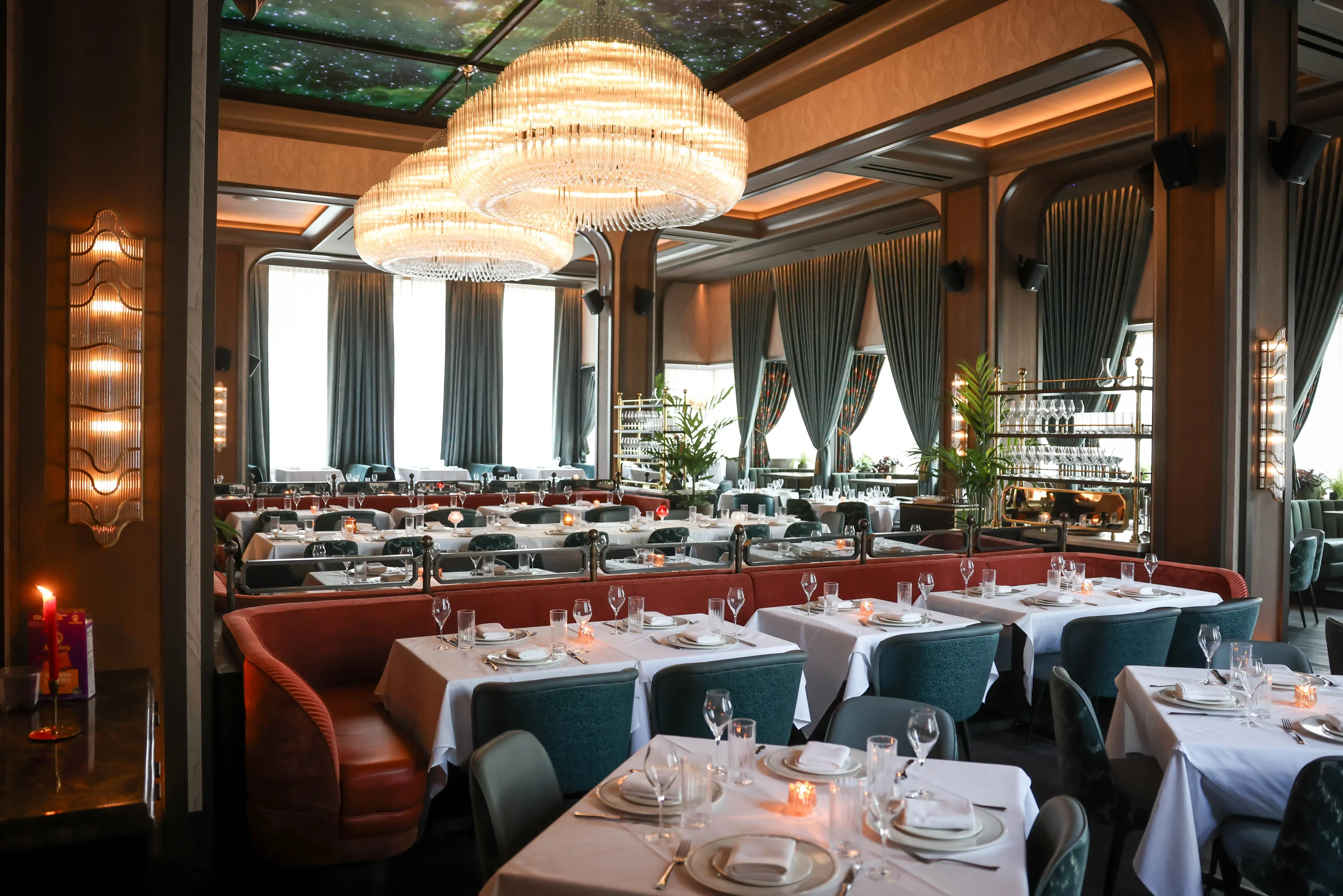The interior of Chicago restaurant The Alston featuring opulent banquets and chandeliers