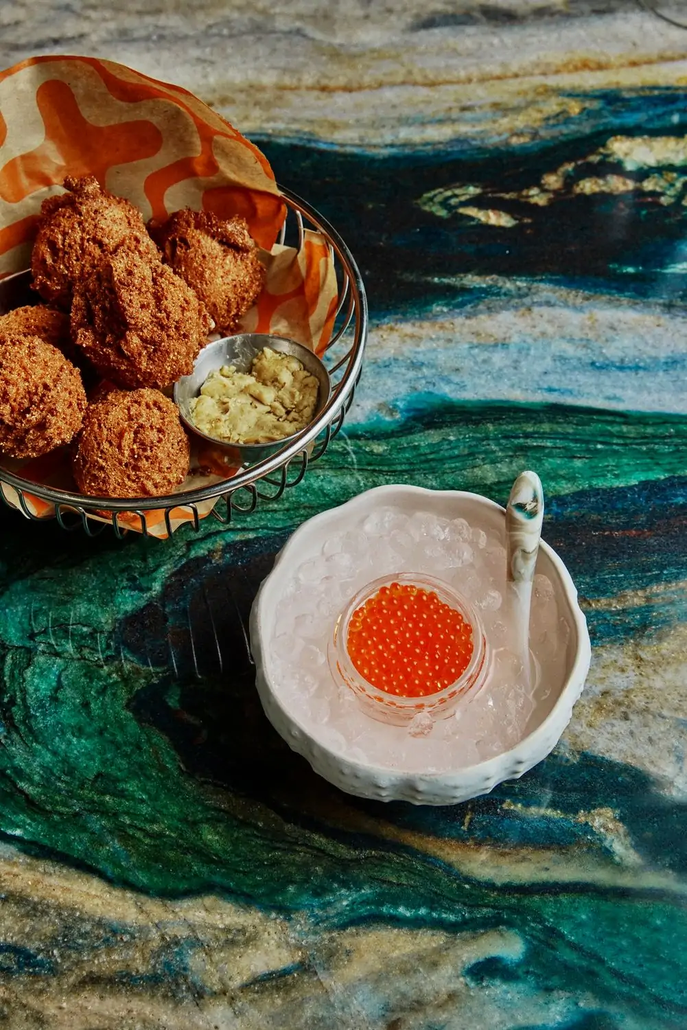 Hush puppies with butter alongside salmon roe at Strange Delight, one of the best seafood restaurants in NYC, book on OpenTable.