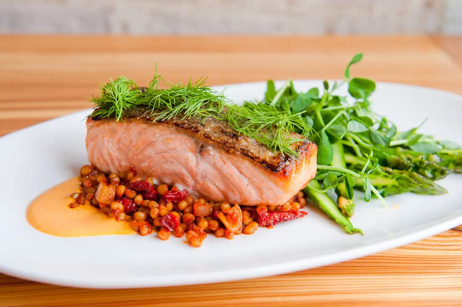 A fillet of salmon on top of grains and alongside a salad at Crave Fishbar, one of the best seafood restaurants in NYC. Reserve on OpenTable.