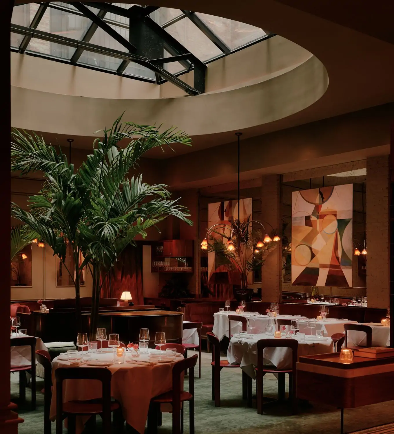Set white-cloth tables under a circular skylight at Brass and The Tusk Bar, a top NYC hotel restaurant found on OpenTable.