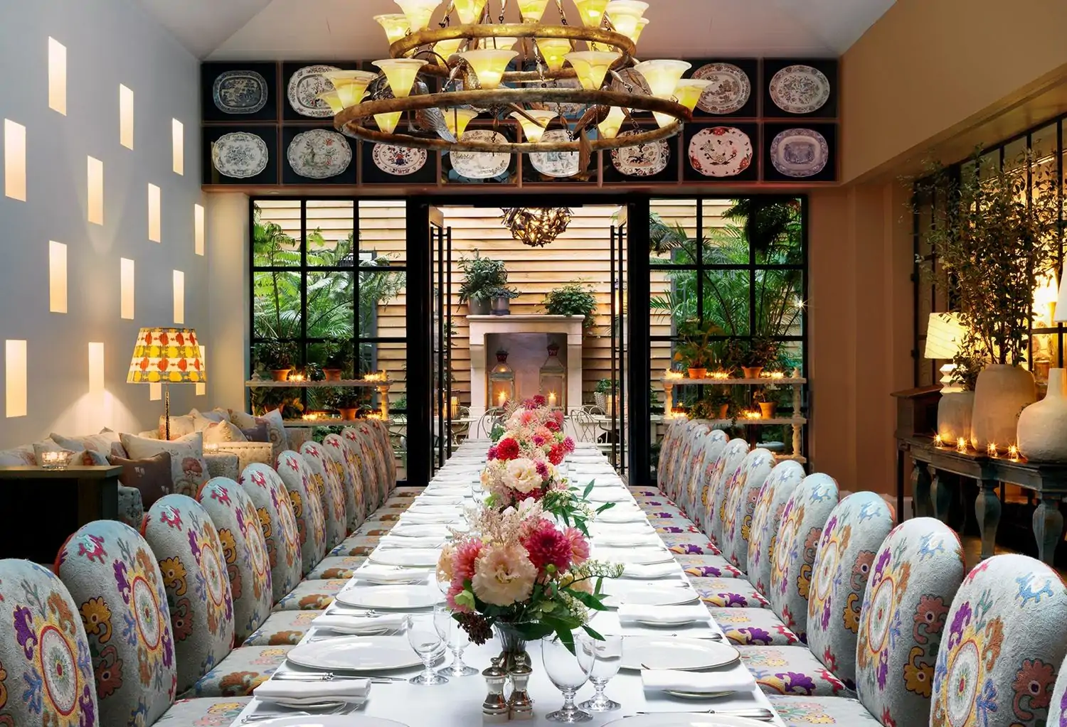 A long table with vibrant bouquets and patterned chairs at The Whitby Bar and Restaurant, one of the best hotel restaurants in NYC, available on OpenTable.