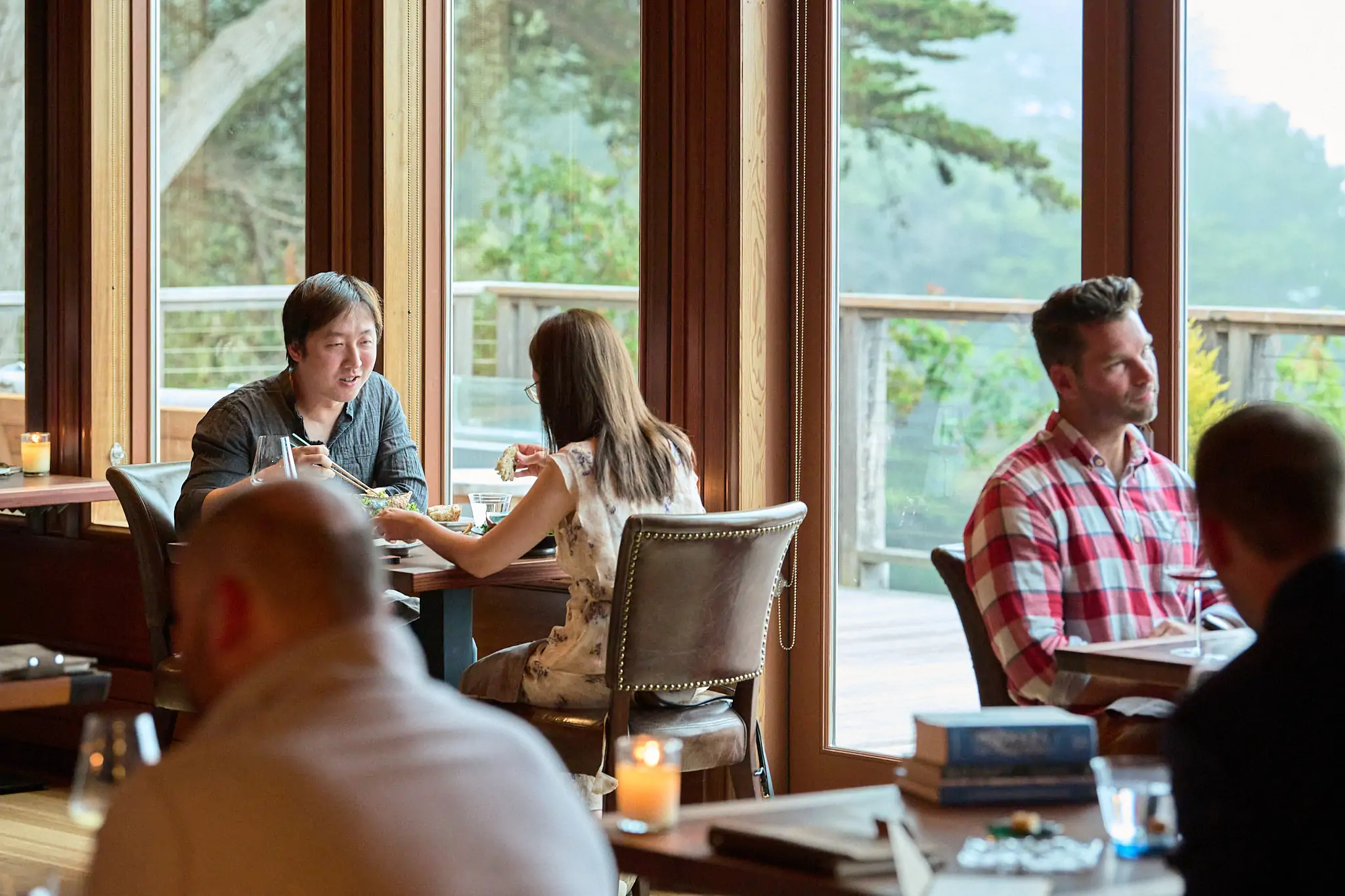 Diners sitting near the windows overlooking the Pacific Ocean at Harbor House Inn