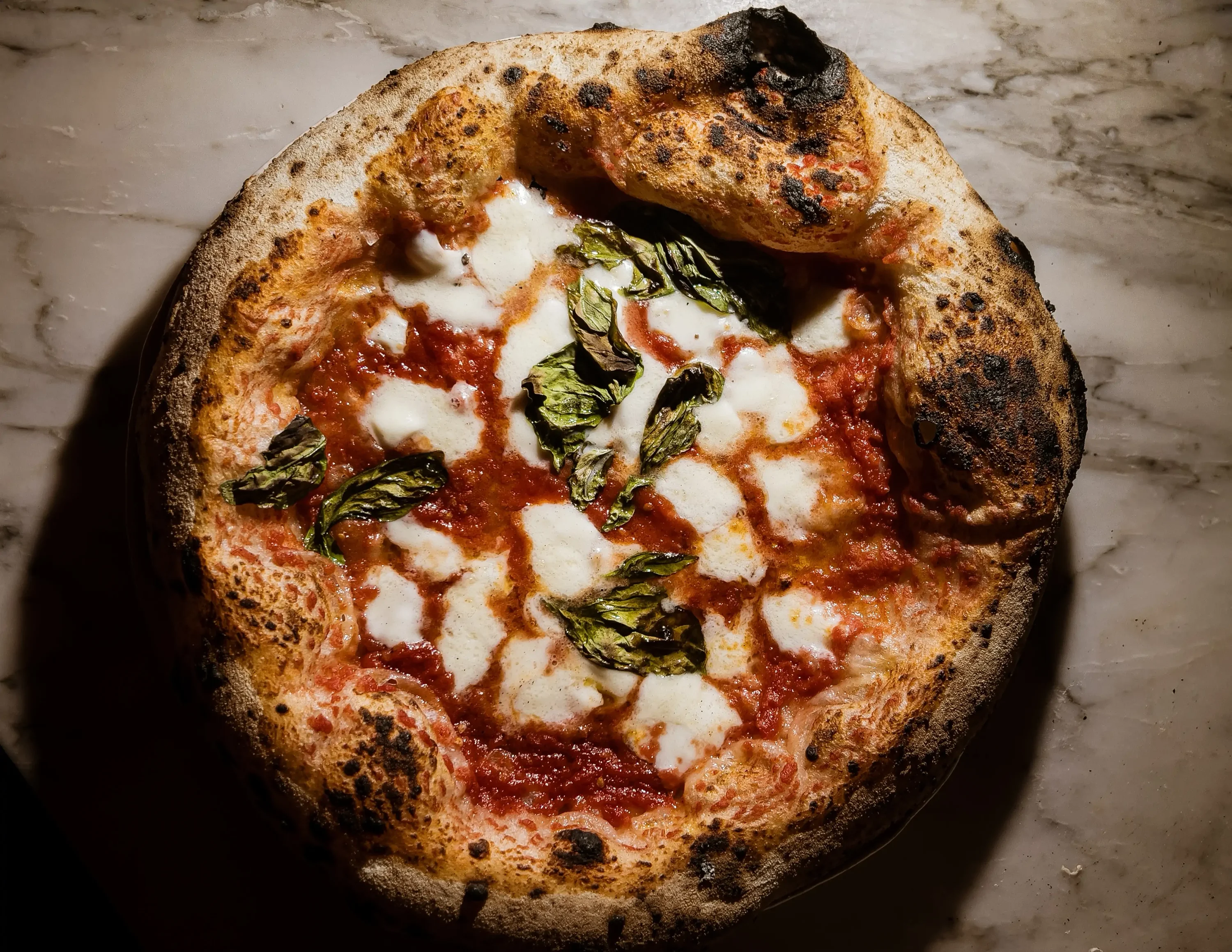 A red pie with cheese and herbs at New York City pizzeria Una Pizza Napoletana