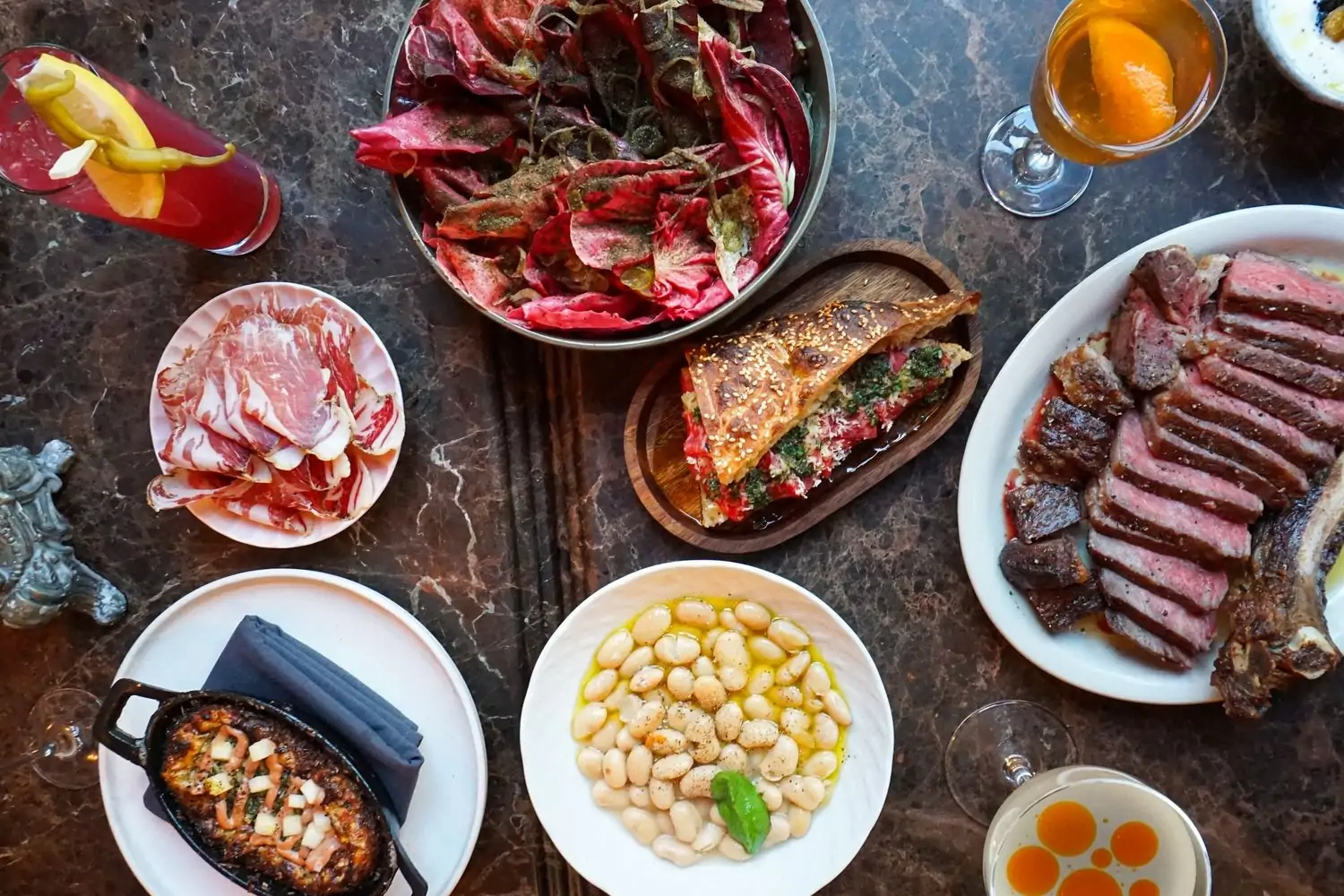 Several dishes on a table at NYC restaurant Foul Witch