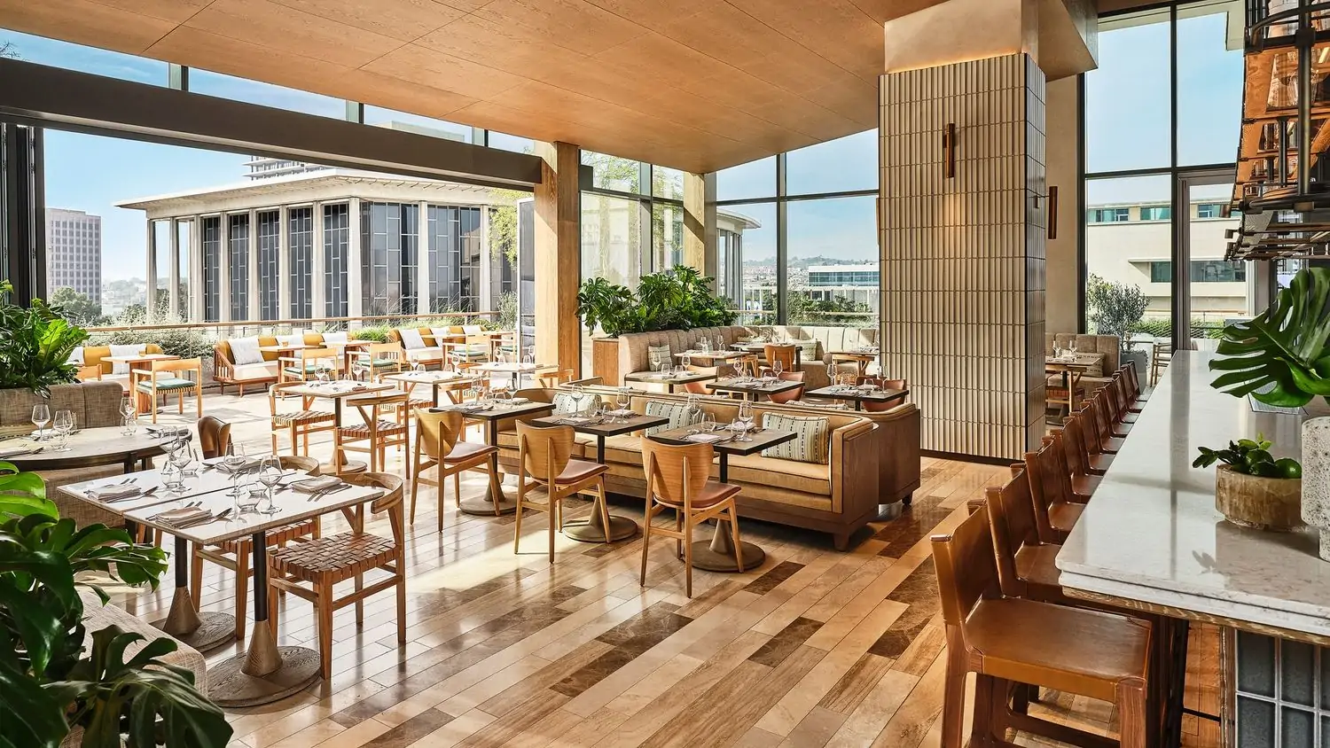 The dining room with wall windows, high ceilings, blonde wood, and views of downtown at San Laurel, in Los Angeles, on OpenTable.