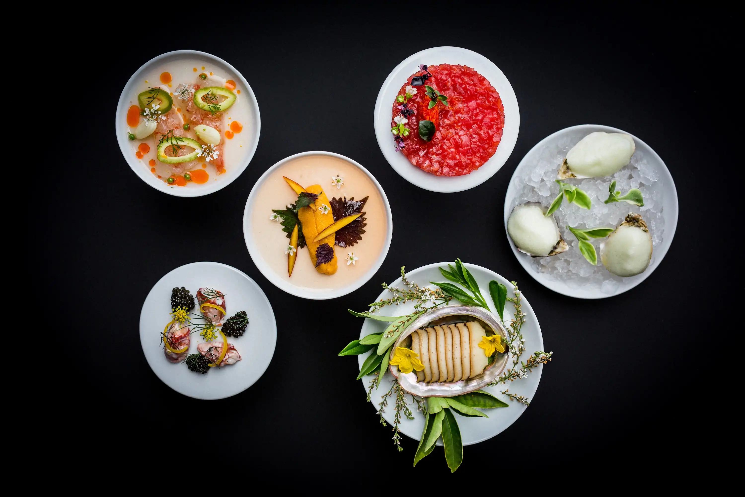 Several seafood dishes placed on a table at Napa restaurant PRESS