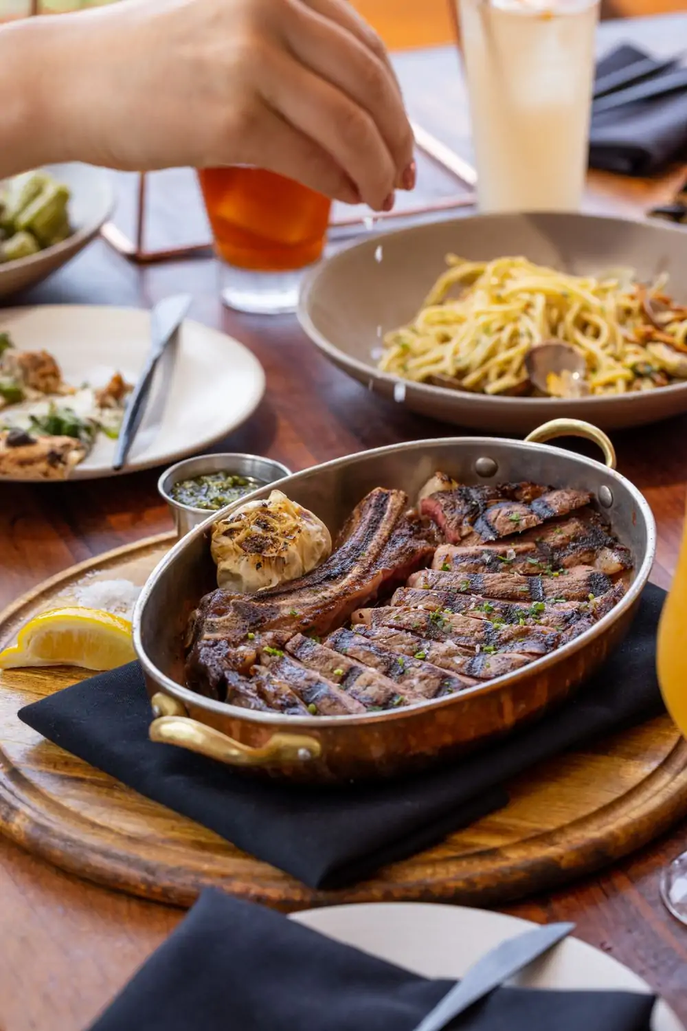 A hand sprinkles salt on a 20-ounce dry-aged rib-eye steak at Élephante, Los Angeles. Reserve on OpenTable.