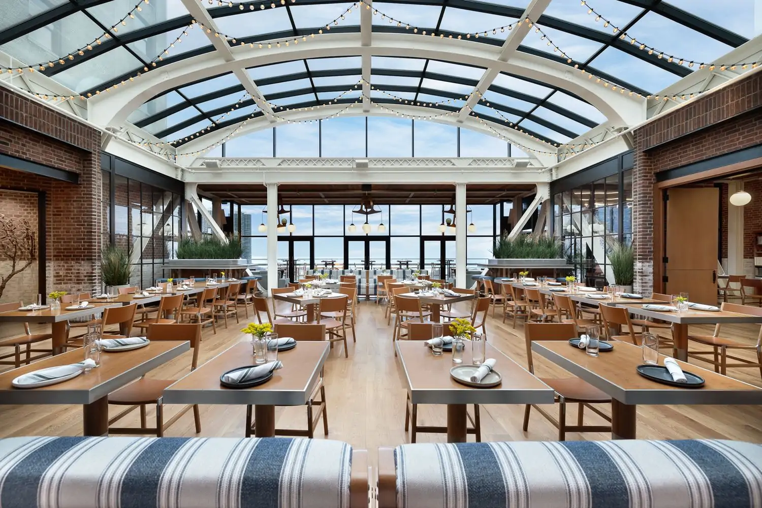 The dining room under a glass atrium at Cindy’s Rooftop, one of the best Chicago Downtown restaurants with a view. Book on OpenTable.