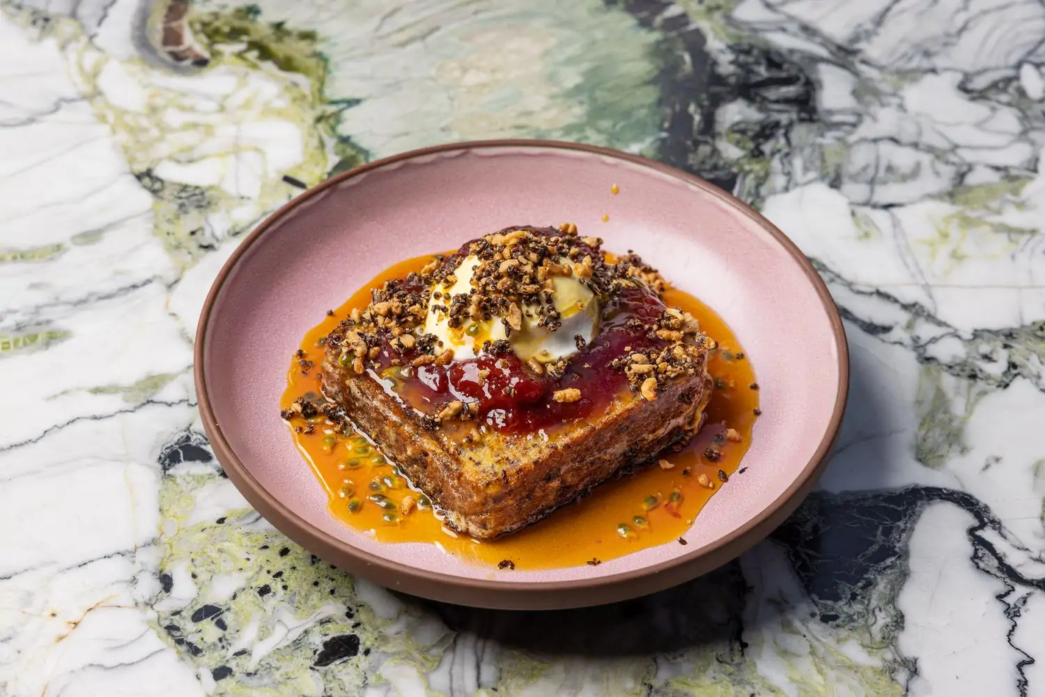 Thick French toast garnished with fruit sauces and toppings at Cabra in Los Angeles. Book on OpenTable.