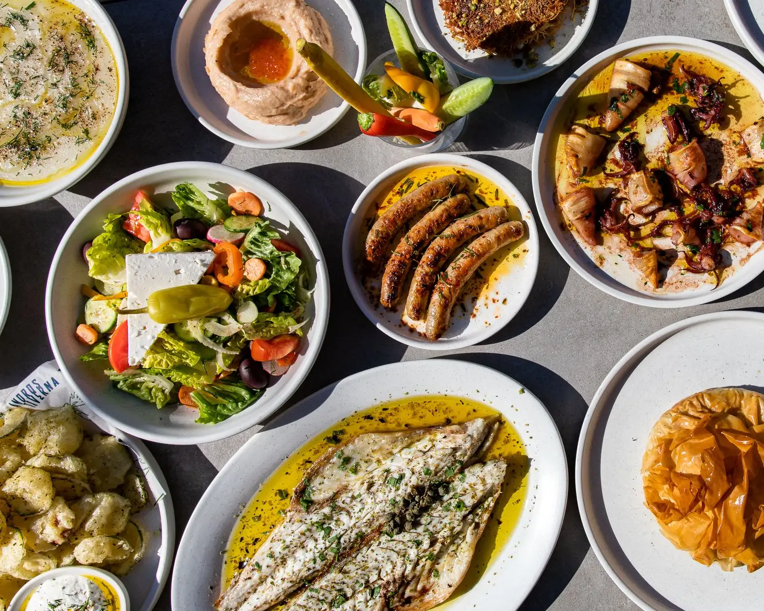 A table with colorful and classic Greek dishes at Andros Taverna in Logan Square, Chicago, on OpenTable.