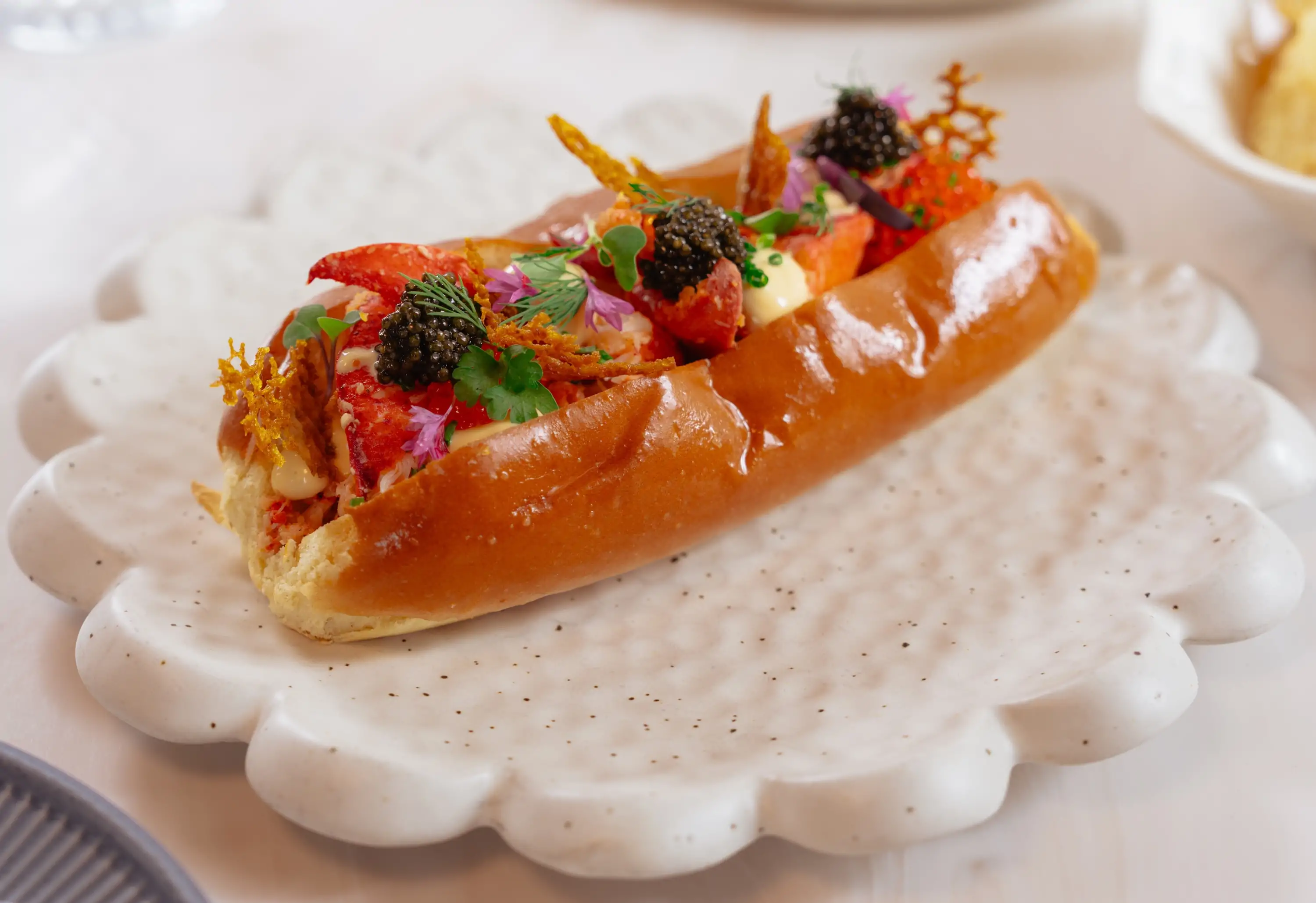 A lobster roll on a white marble plate at San Francisco restaurant Alora