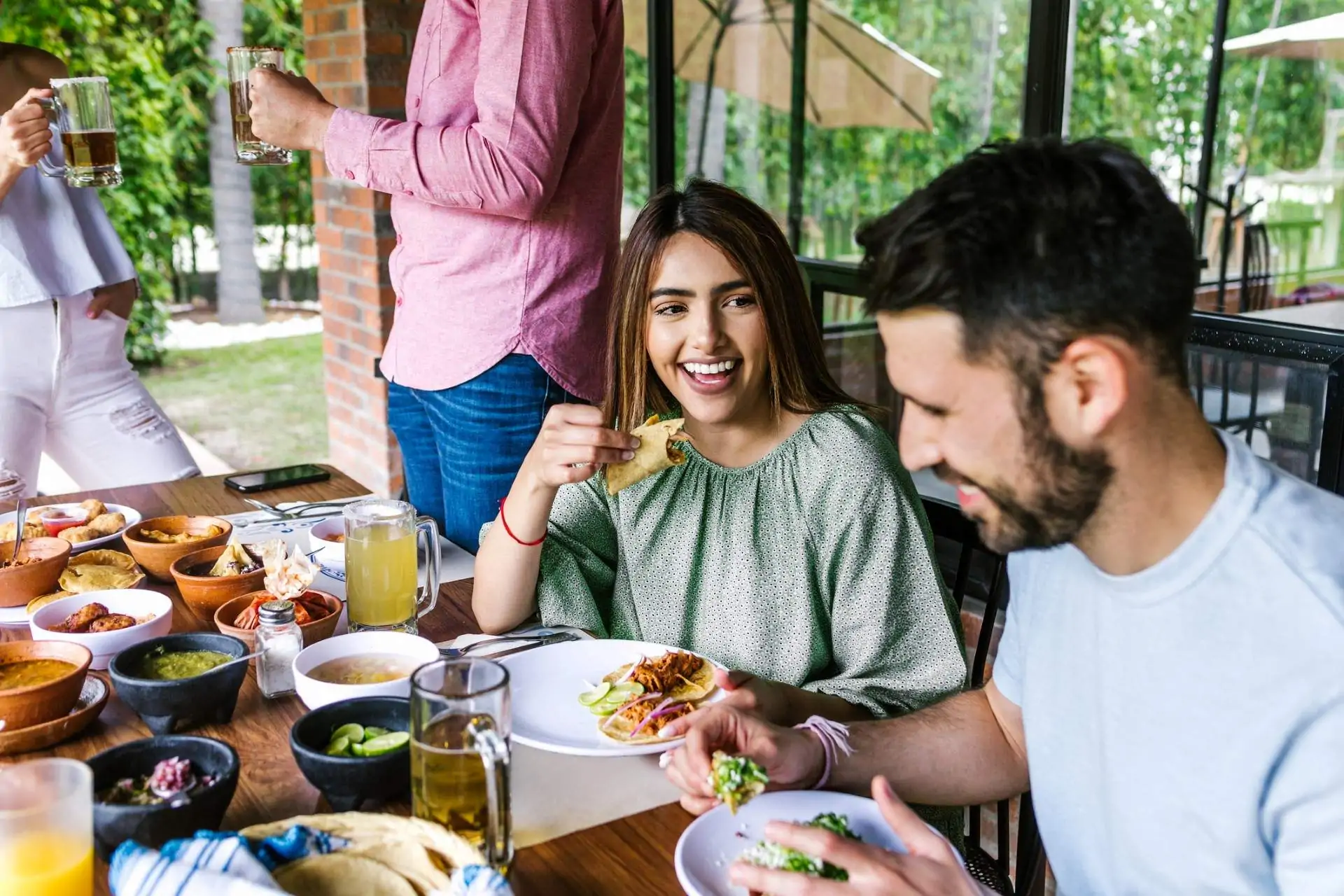 Image depicts a group of people dining out at a restaurant, all wearing colorful shirts.