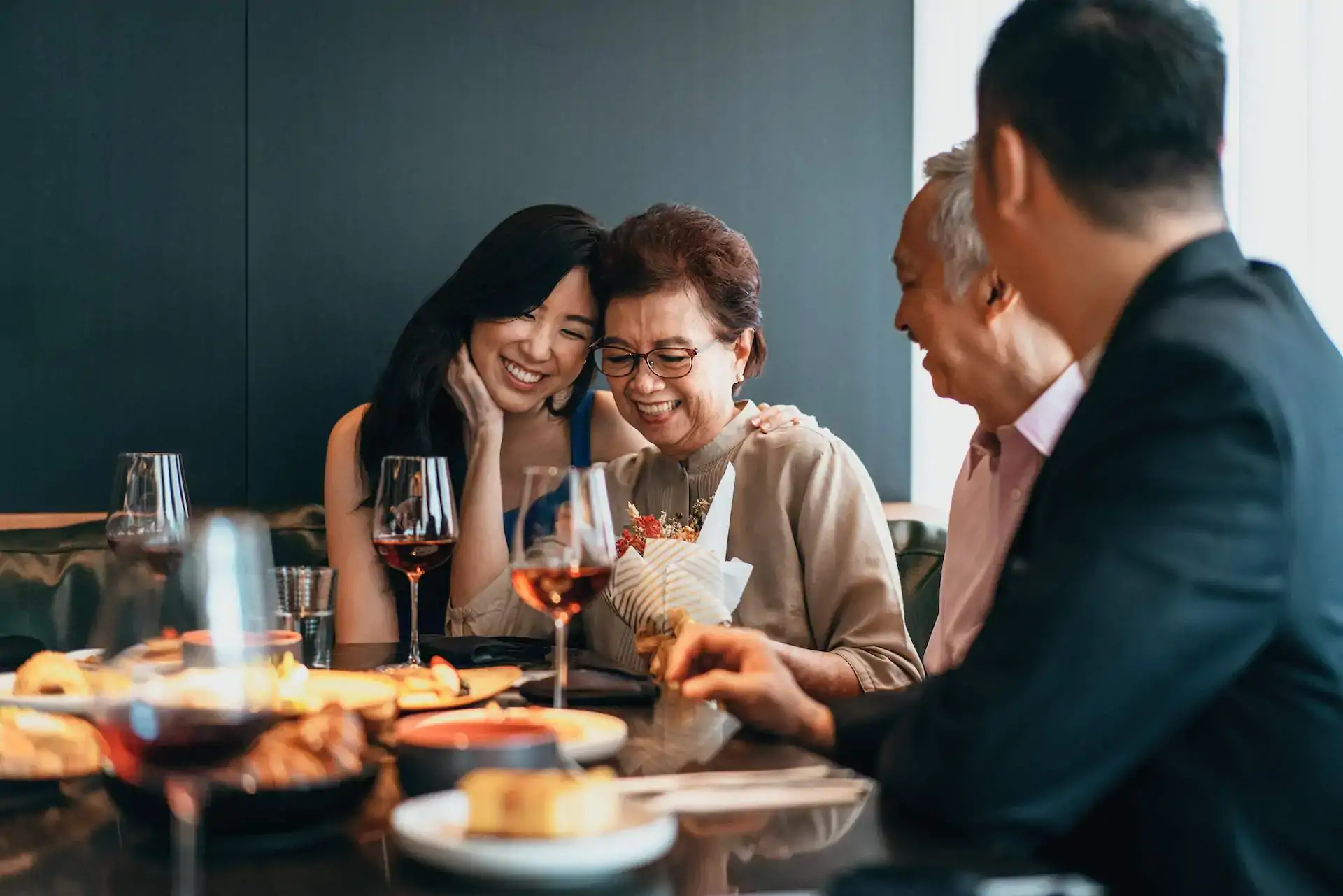 A group of smiling guests enjoying an intimate meal with wine, representing the successful outcome of a unique dining experience.