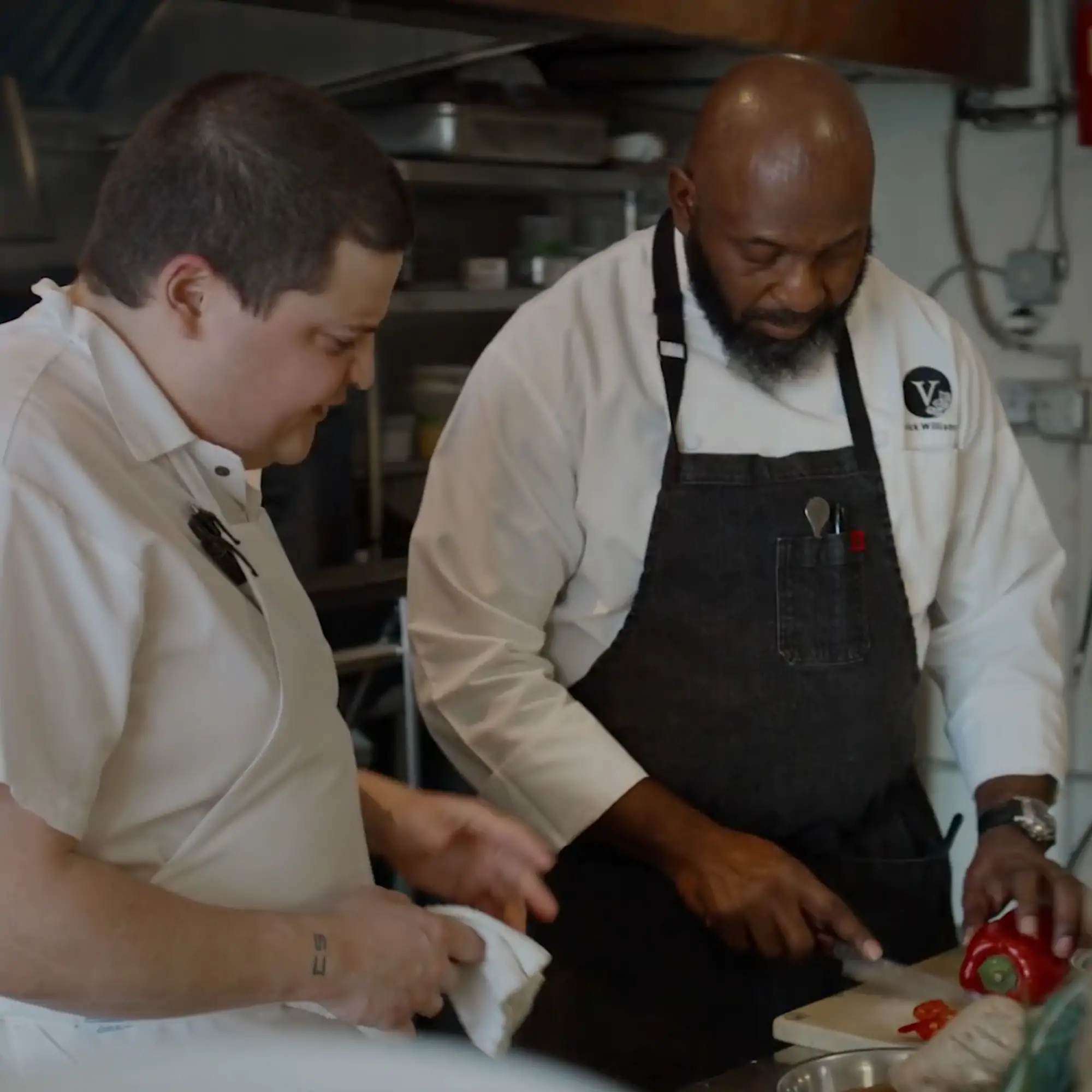 Chef Ian Graye and chef Erick Williams preparing vegan dishes together in the kitchen at Pietramala for an OpenTable 'Meet Me At' feature.