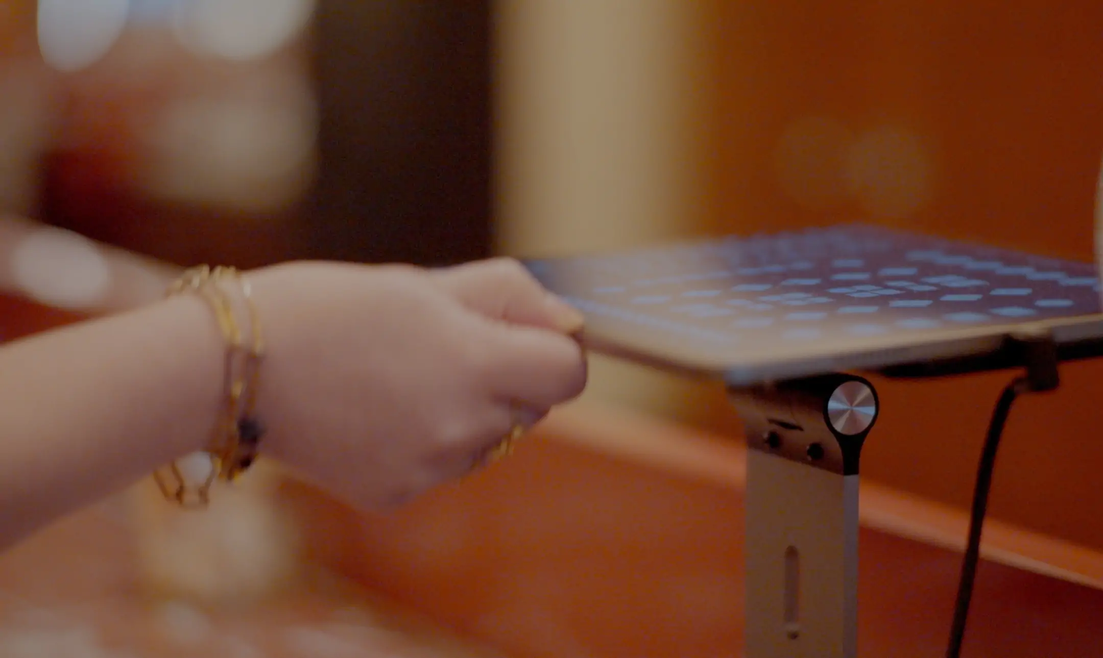 A close-up of a restaurant staff member using a tablet mounted on a stand, representing the use of technology for guest communications.
